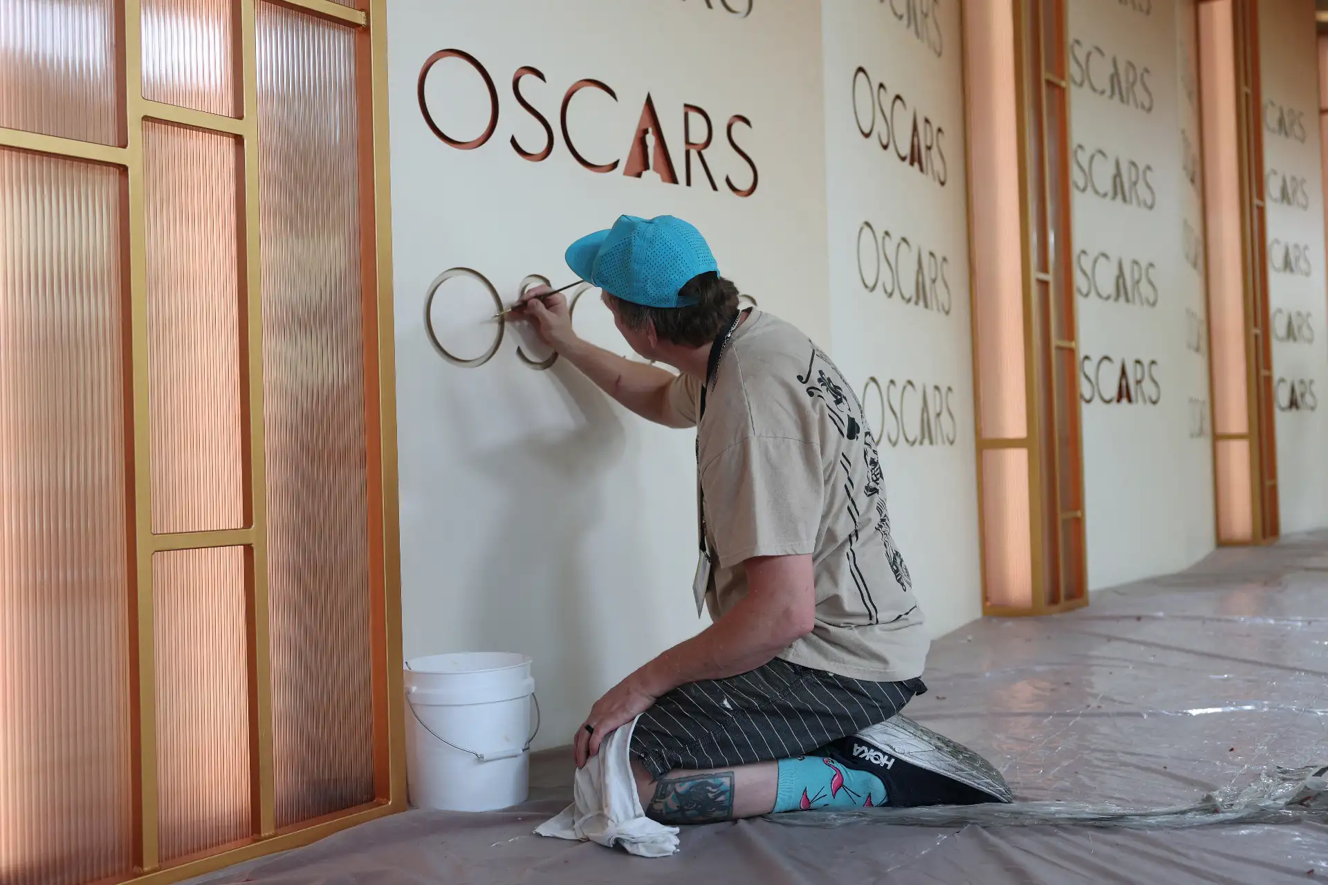 Un trabajador retoca el telón de fondo mientras se realizan los preparativos en la alfombra roja para la 98.ª edición de los Premios Óscar en Hollywood, California.
Foto: AFP
