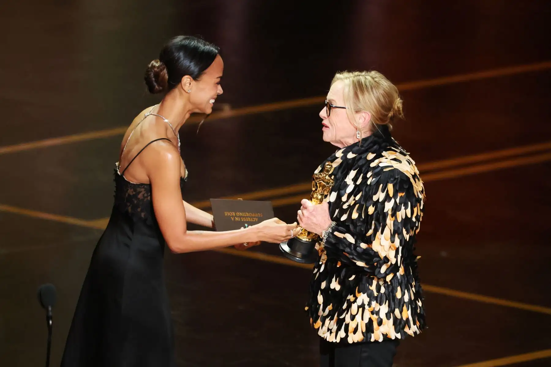 Amy Madigan recibe el premio de manos de Zoe Saldana tras ganar el Óscar a la Mejor Actriz de Reparto por 