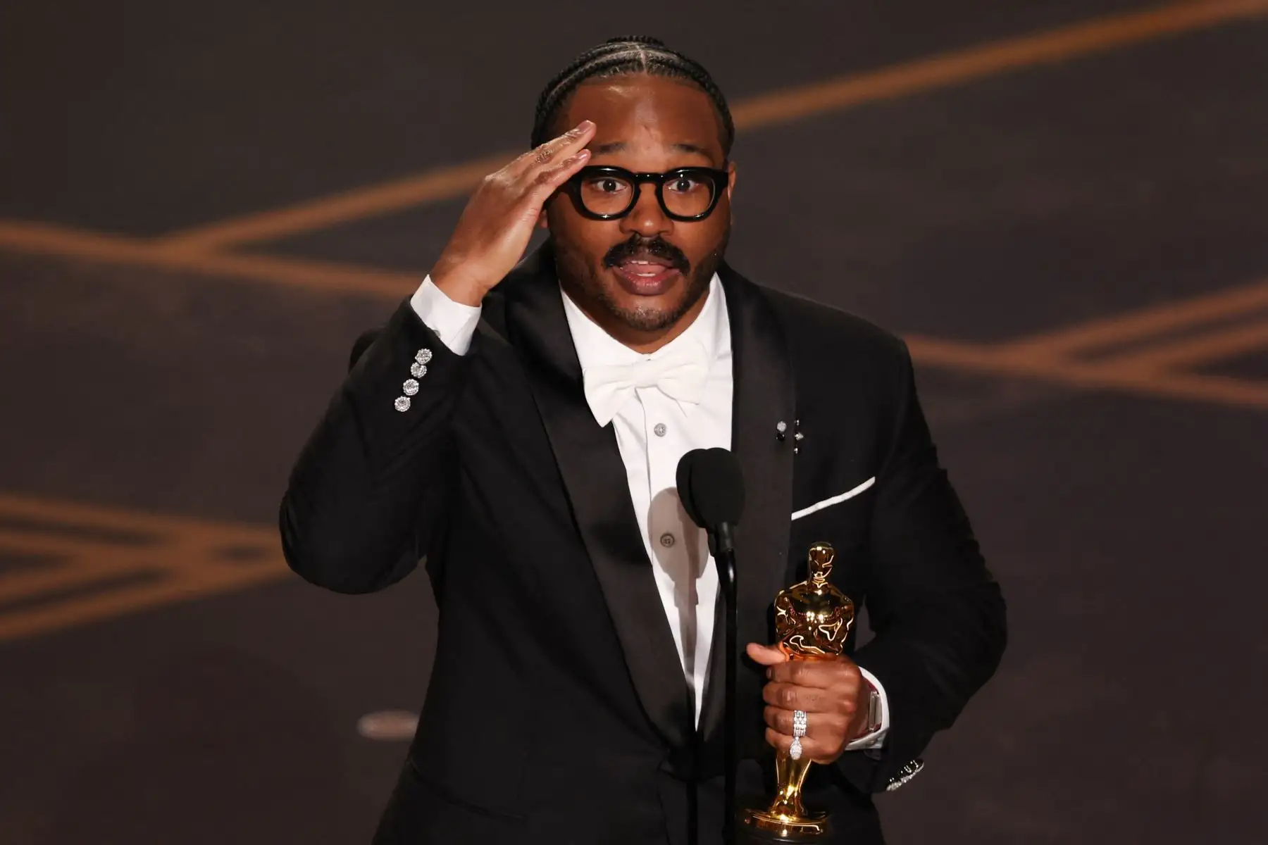 El director y productor de cine estadounidense Ryan Coogler recibe el premio al Mejor Guion Original por "Sinners" en el escenario durante la 98.ª edición de los Premios Óscar en el Dolby Theatre de Hollywood, California.
Foto: AFP