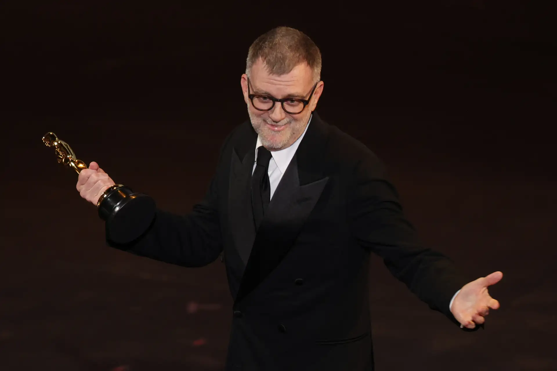 El cineasta estadounidense Paul Thomas Anderson recibe el Oscar al Mejor Guion Adaptado por "One Battle After Another" en el escenario durante la 98.ª edición de los Premios Óscar en el Dolby Theatre de Hollywood, California.
Foto: AFP