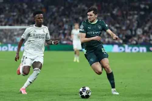 El delantero brasileño del Real Madrid, Vinicius Junior  disputa el balón con el defensa uzbeko del Manchester City, Abdukodir Khusanov,