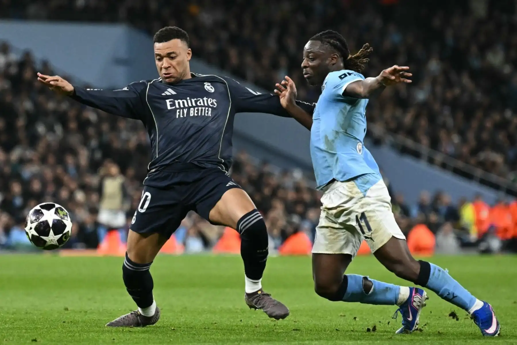 El centrocampista belga del Manchester City, Jeremy Doku , disputa el balón con el delantero francés del Real Madrid, Kylian Mbappé, durante el partido de vuelta de los octavos de final de la UEFA Champions League entre el Manchester City y el Real Madrid. AFP