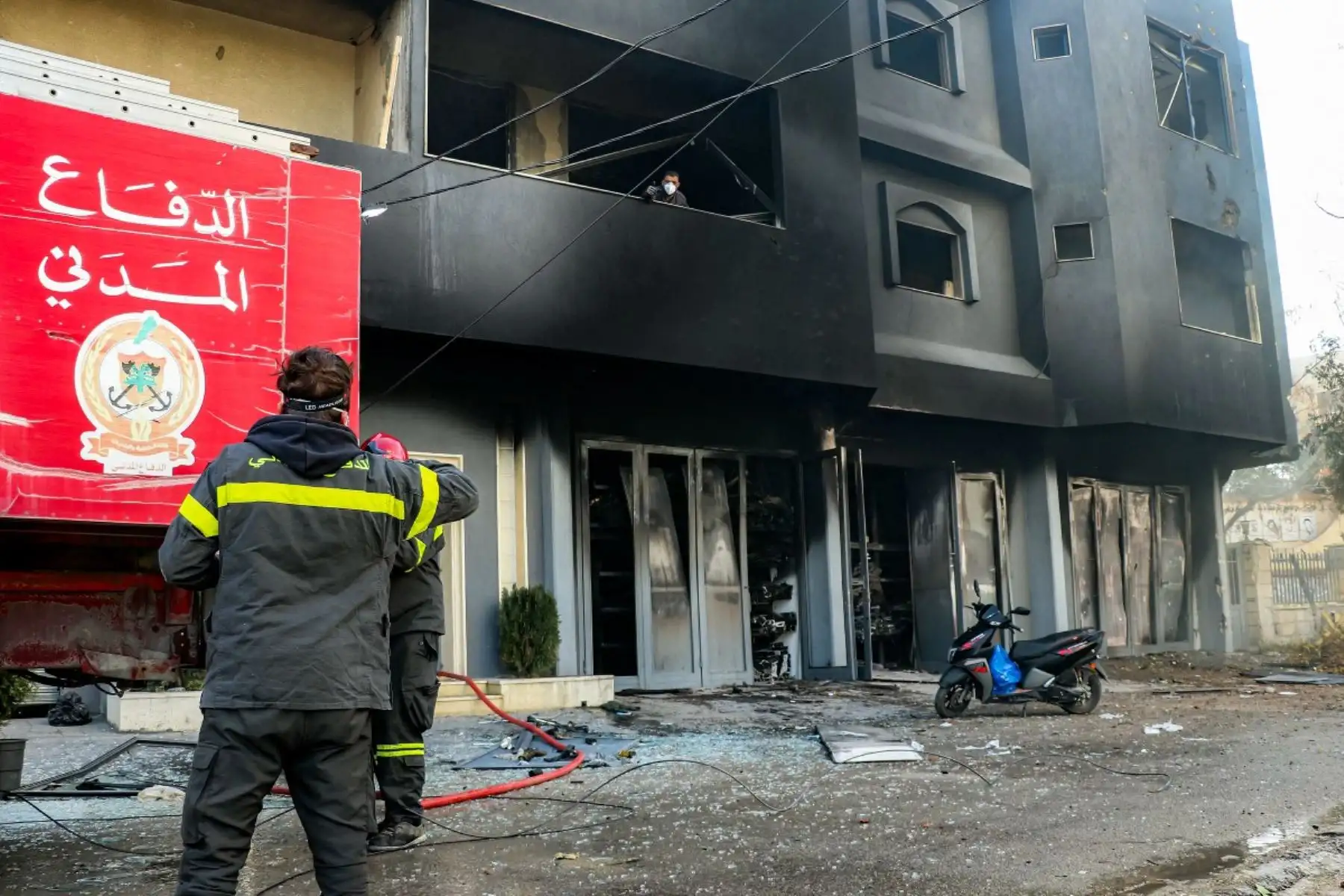 Bomberos permanecen de pie frente a un edificio incendiado tras el bombardeo israelí de la ciudad de Abbassiyeh, cerca de Tiro, ciudad costera del sur del Líbano. Foto: AFP