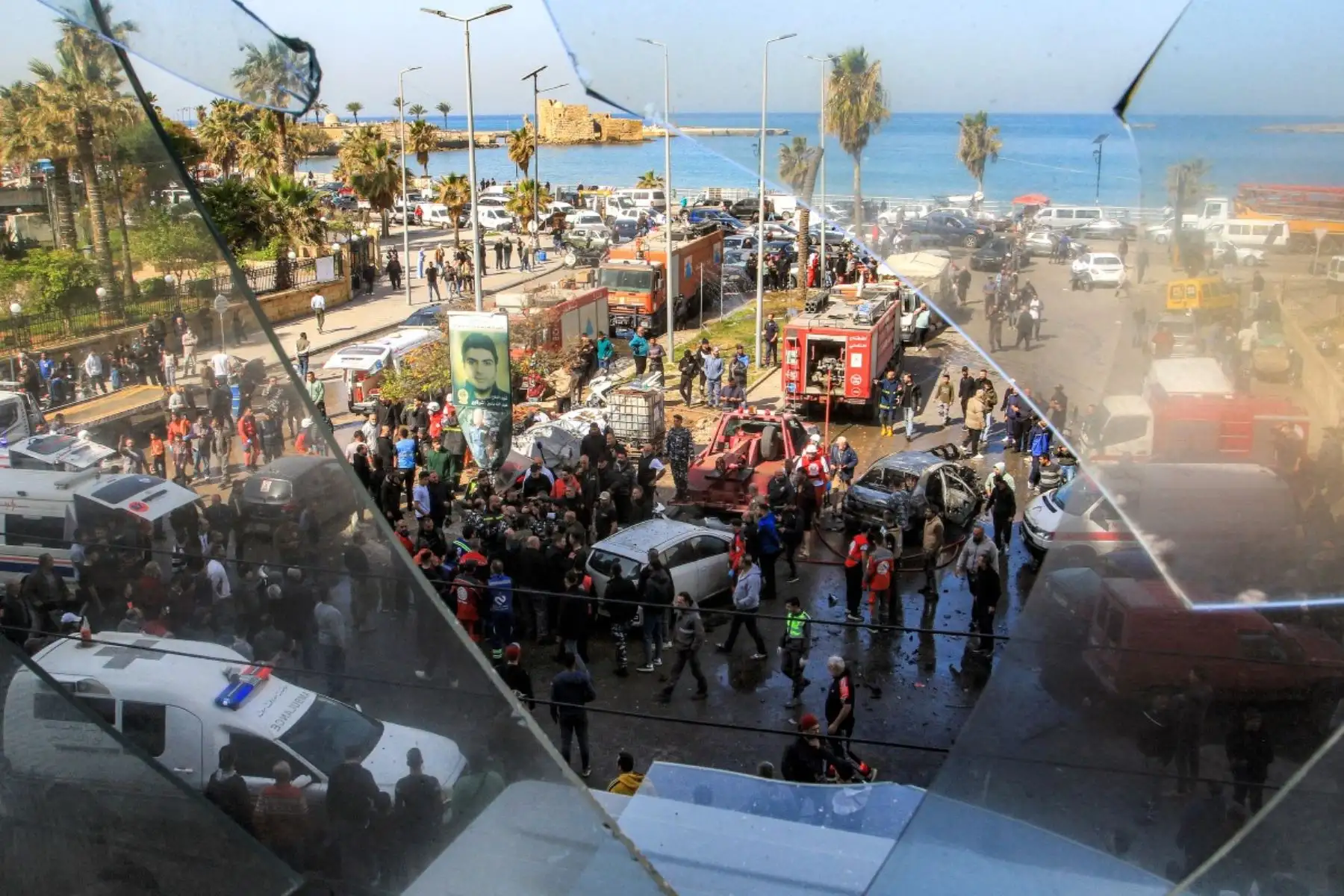 Miembros de la defensa civil se congregan alrededor de un vehículo destruido que fue blanco de un bombardeo israelí en la ciudad costera de Sidón, al sur del Líbano. Foto: AFP
