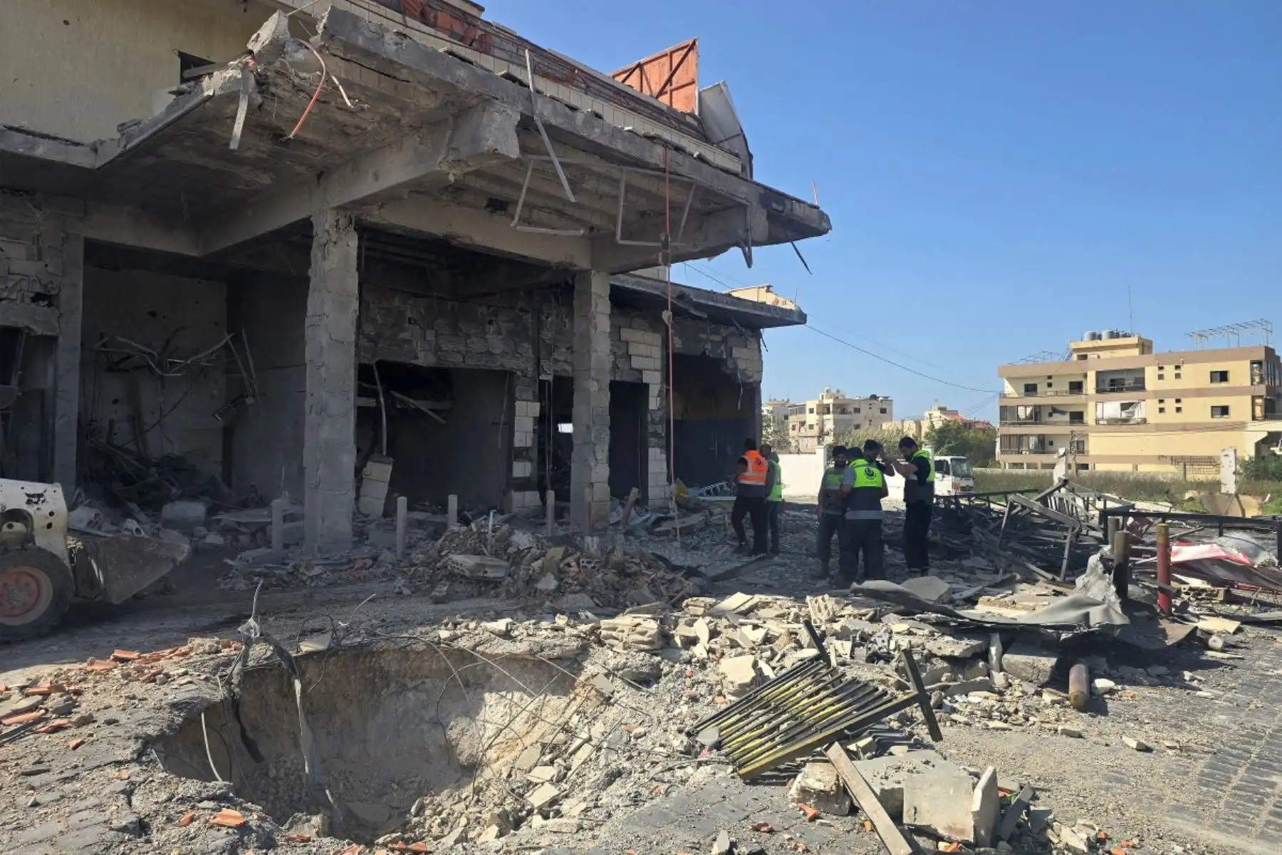 Miembros de la defensa civil inspeccionan un edificio que fue alcanzado por un bombardeo israelí dirigido contra una gasolinera en la ciudad costera de Tiro, al sur del Líbano. Foto: AFP
