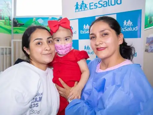 Milagritos superó tumor hepático maligno en etapa avanzada gracias al trabajo especializado en EsSalud. En la foto, aparece junto a su mamá (con bata blanca) y a su tía (con bata azul). Foto: Difusión