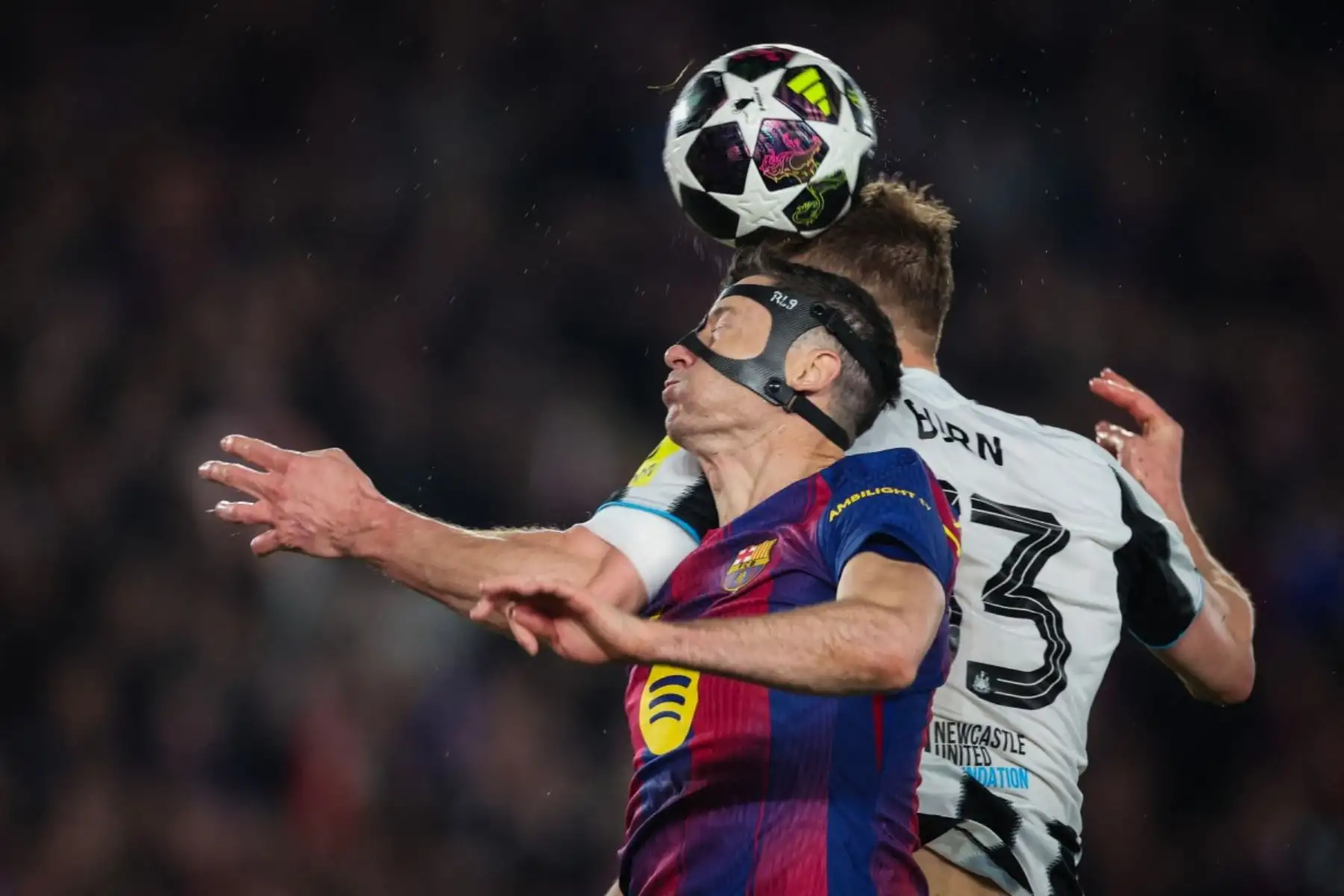 El delantero polaco del Barcelona, ​​Robert Lewandowski y el defensa inglés del Newcastle United, Dan Burn, disputan un balón de cabeza durante el partido de vuelta de los octavos de final de la Liga de Campeones de la UEFA entre el FC Barcelona y el Newcastle United en el estadio Camp Nou de Barcelona. Foto: AFP