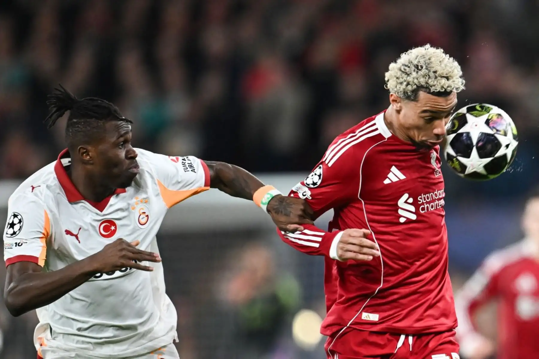 El defensa marfileño del Galatasaray, Wilfried Singo, empuja al delantero francés del Liverpool, Hugo Ekitike, que cabecea el balón durante el partido de vuelta de los octavos de final de la Liga de Campeones de la UEFA entre el Liverpool y el Galatasaray. Foto: AFP