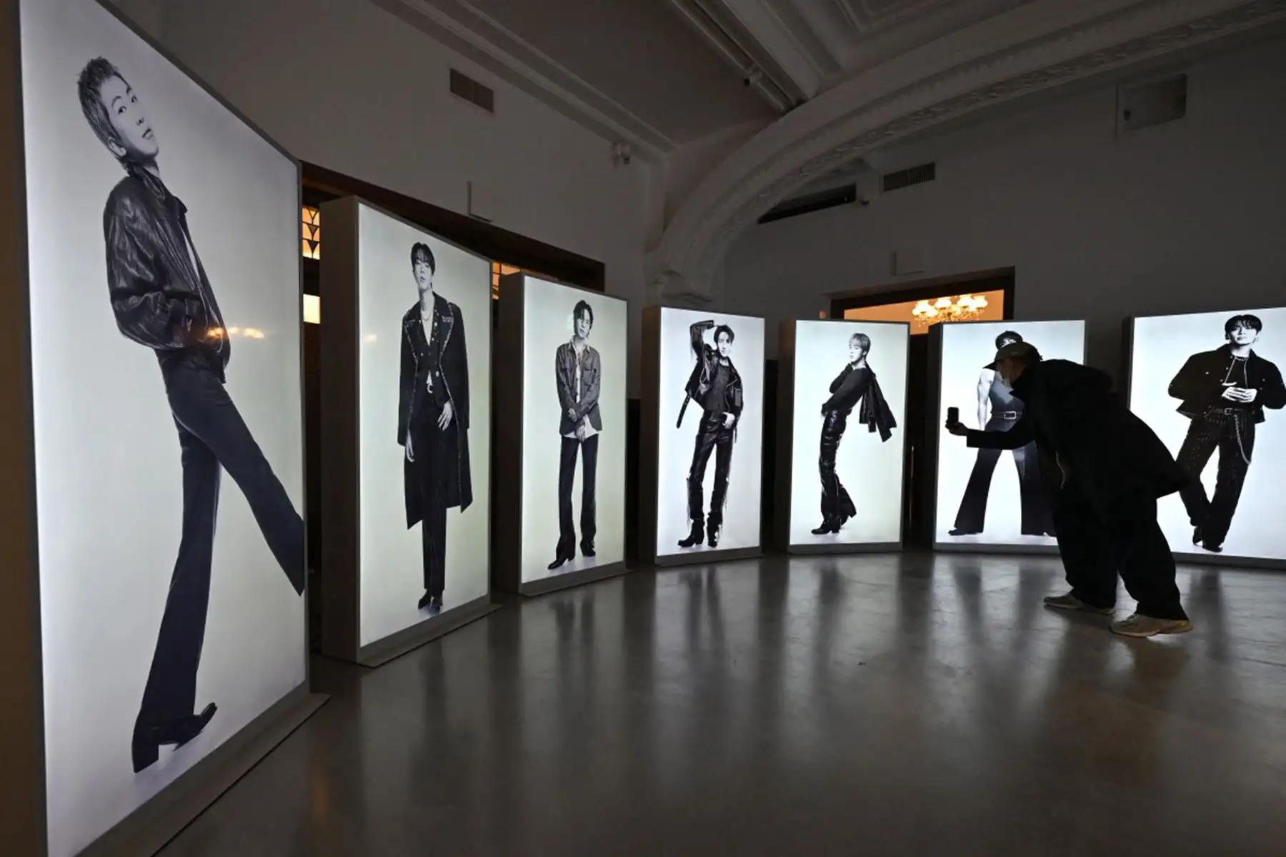 Un visitante toma una foto de los  integrantes de BTS expuestos en una tienda temporal de BTS en The Heritage, perteneciente a los grandes almacenes Shinsegae, en Seúl. Foto: AFP