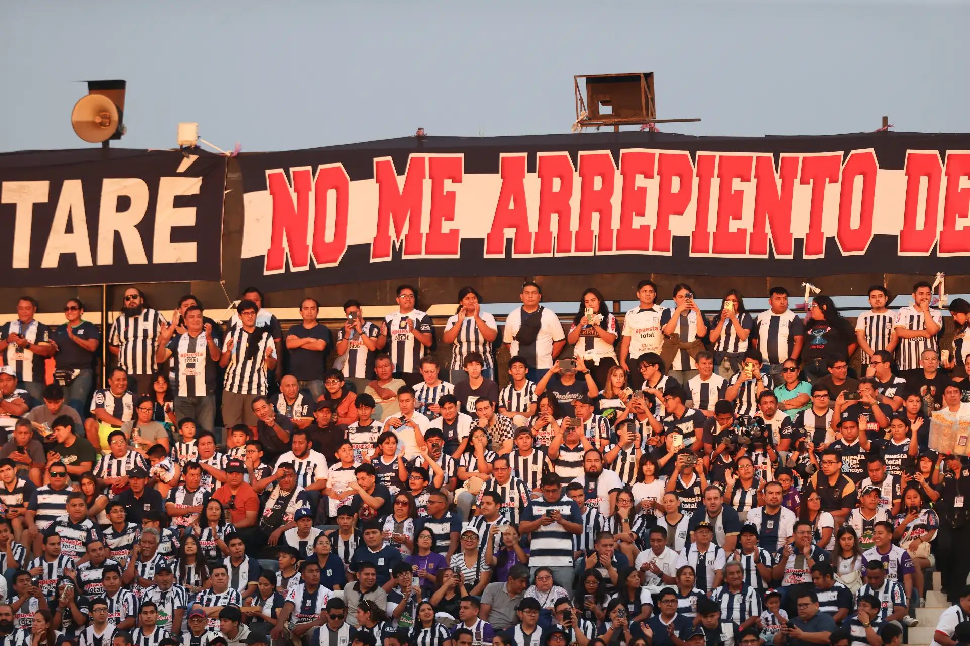 En medio de gran expectativa, hinchas blanquiazules se congregan en el Estadio Alejandro Villanueva a la espera del inicio del partido entre Alianza Lima y Juan Pablo II, correspondiente a la fecha 8 del Torneo Apertura de la Liga 1. Con cánticos y banderas, la afición íntima vive la previa con entusiasmo, confiando en un resultado favorable para su equipo. 
Foto: ANDINA/Jhonel Rodríguez Robles