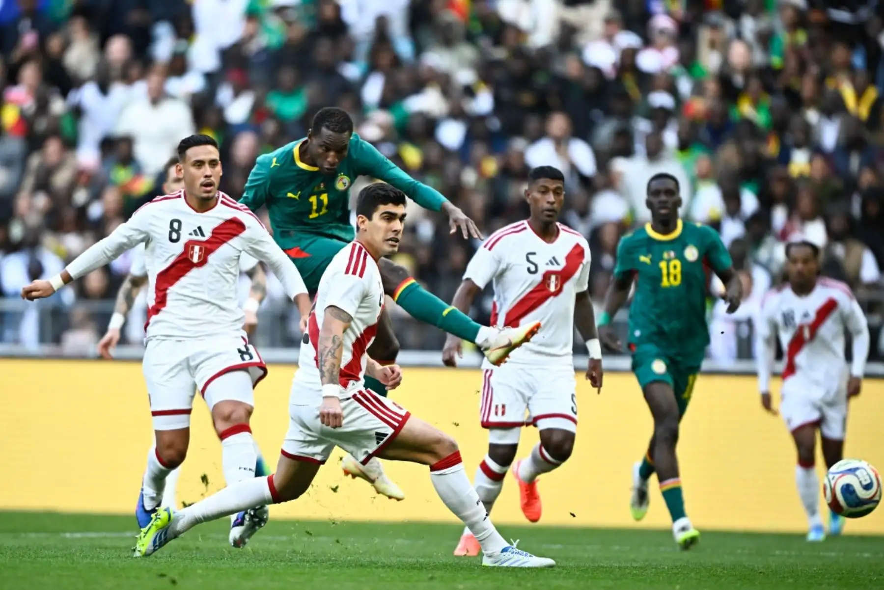 El delantero senegalés, Nicolas Jackson, dispara el balón superando al centrocampista peruano, Erick Noriega, durante el partido amistoso internacional de fútbol entre Senegal y Perú en el Stade de France en Saint-Denis, al norte de París. Foto: ANDINA/AFP