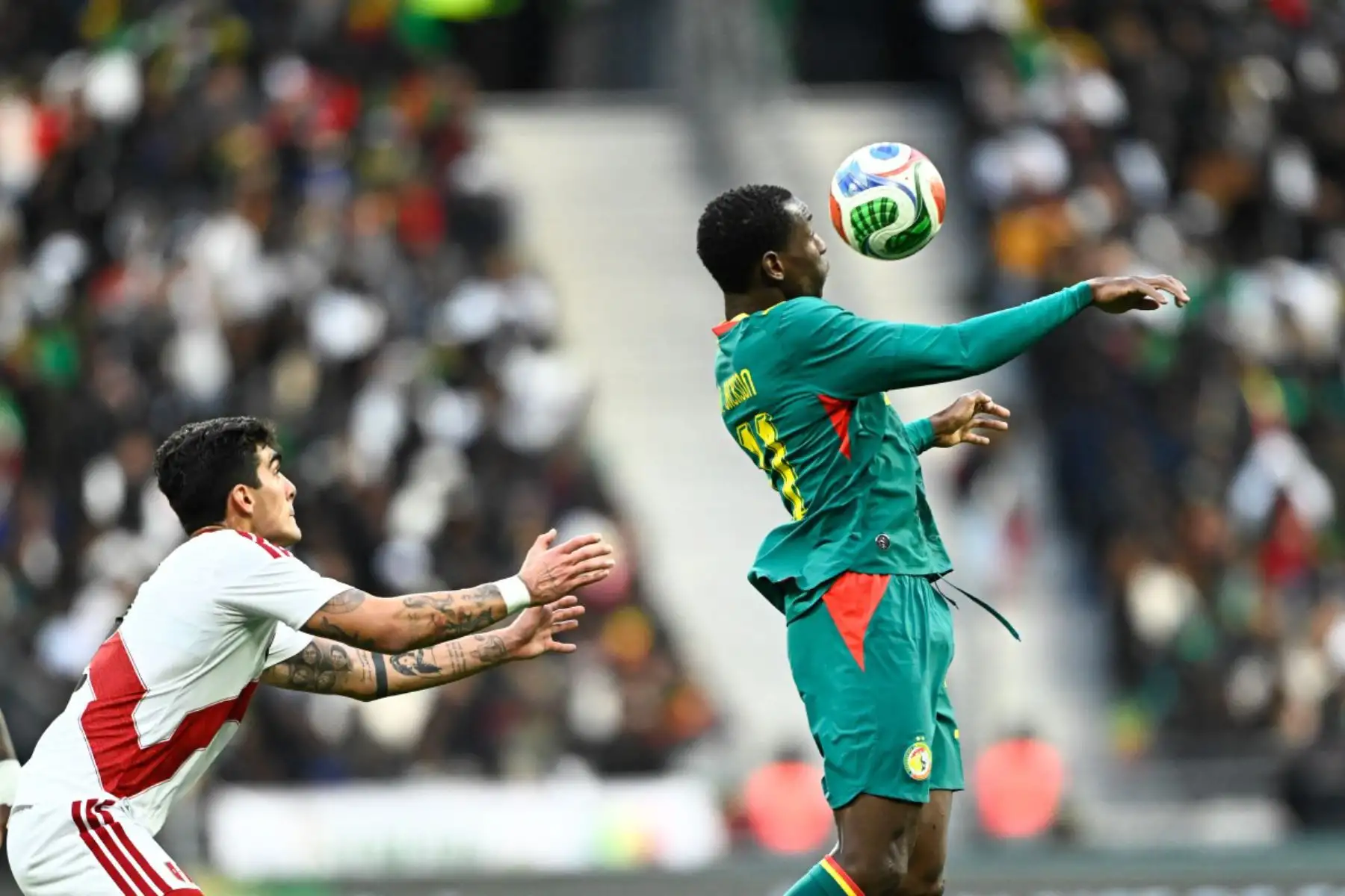 El delantero senegalés Nicolas Jackson, del ranking, disputa el balón con el defensa peruano Alfonso Barco, durante el partido amistoso internacional entre Senegal y Perú en el Stade de France de Saint-Denis, al norte de París. Foto: ANDINA/AFP