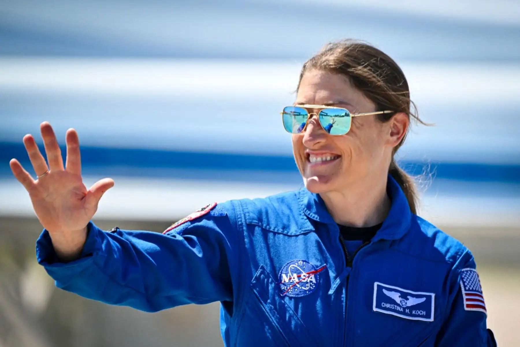 La astronauta Christina Koch saludó durante la presentación oficial de Artemis II, misión en la que se convertirá en la primera mujer en viajar más allá de la órbita terrestre hacia la Luna, tras haber permanecido 328 días consecutivos en la Estación Espacial Internacional, récord histórico femenino en la NASA. Foto: AFP.
