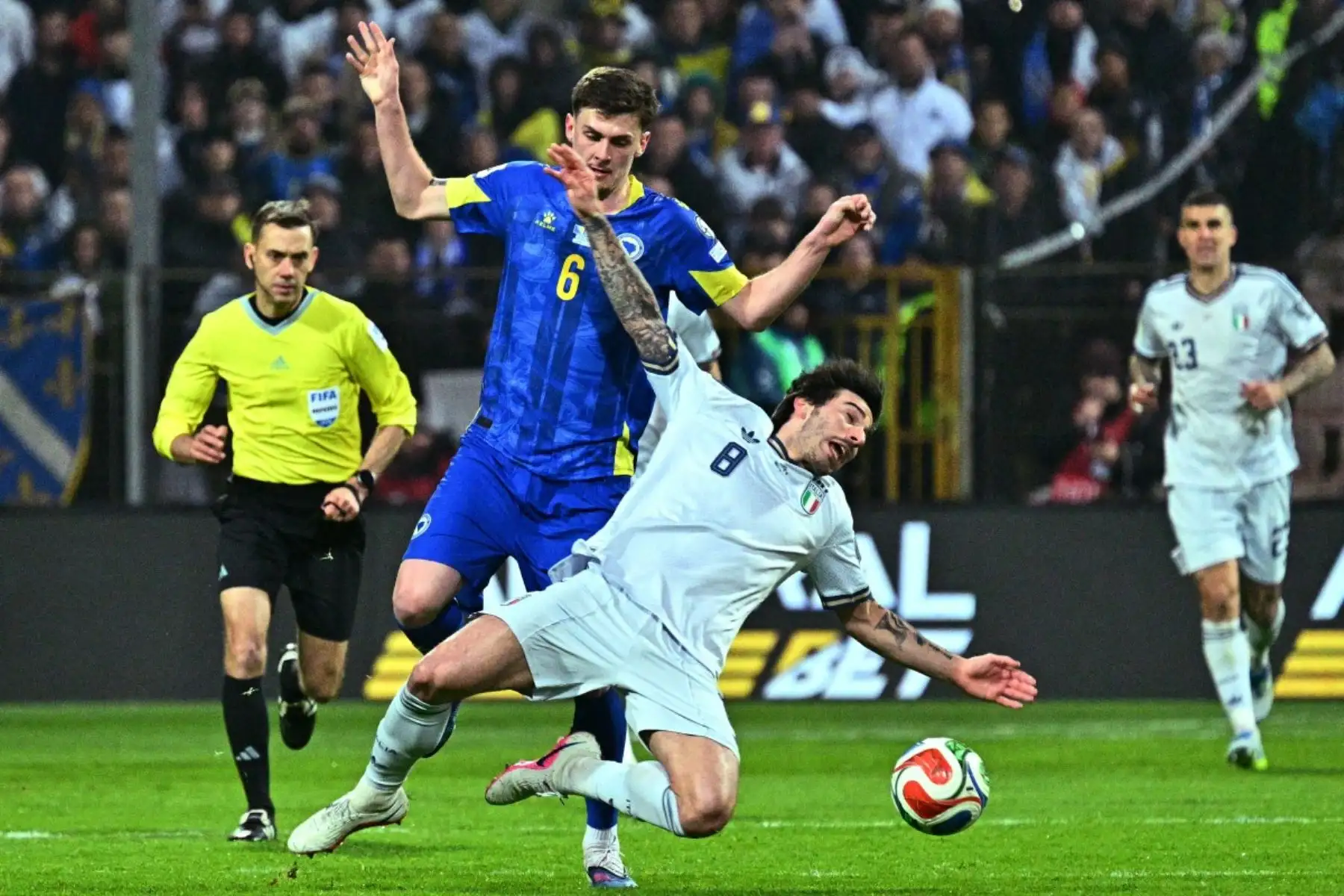 El centrocampista bosnio Benjamin Tahirovic, disputa el balón con el centrocampista italiano Sandro Tonali, número 08, durante la final de clasificación europea para la Copa Mundial de la FIFA 2026 entre Bosnia-Herzegovina e Italia, disputada en el estadio Bilino-Polje de Zenica. Foto: AFP