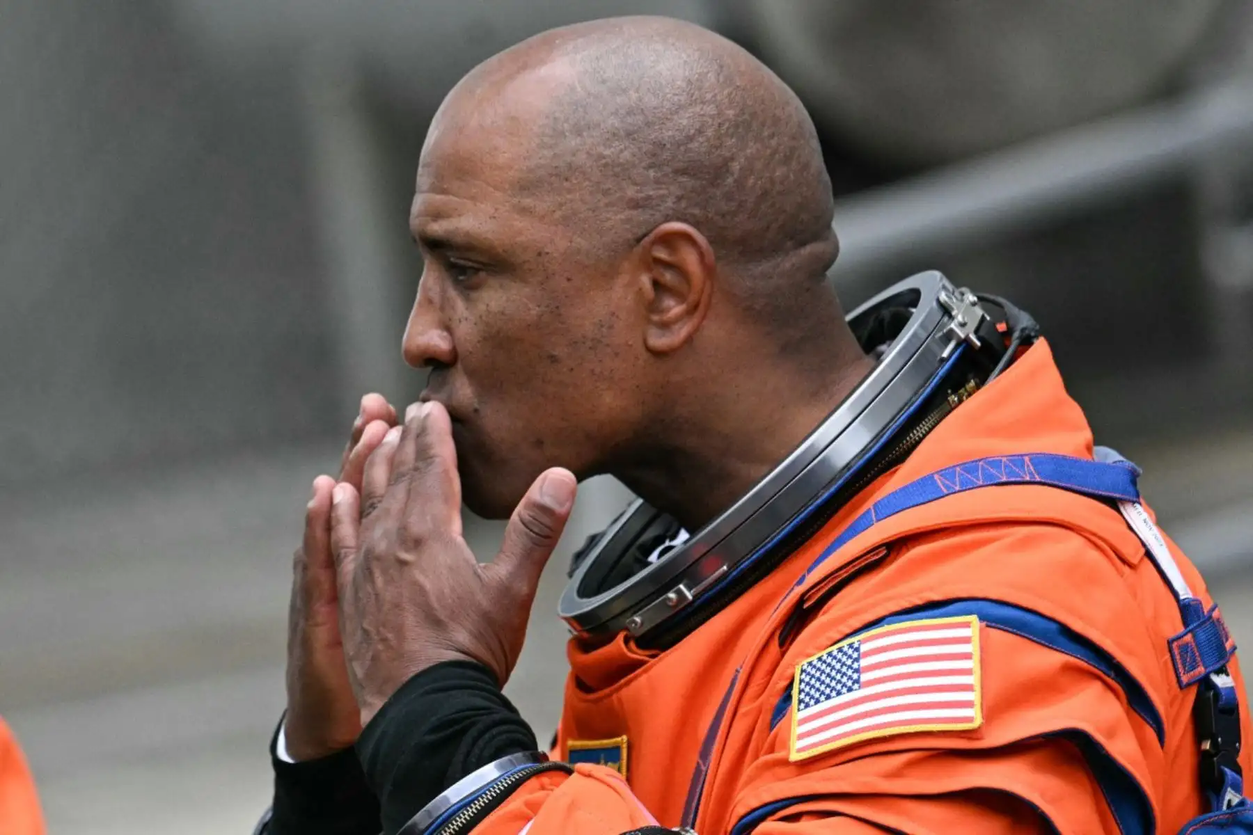 El astronauta de la NASA Victor Glover, piloto de Artemis II, lanza un beso a sus amigos y familiares mientras sale antes de abordar un autobús que lo llevará a la plataforma de lanzamiento para abordar el cohete Space Launch System (SLS) para la misión lunar tripulada Artemis II en el Centro Espacial Kennedy en Cabo Cañaveral, Florida.  AFP