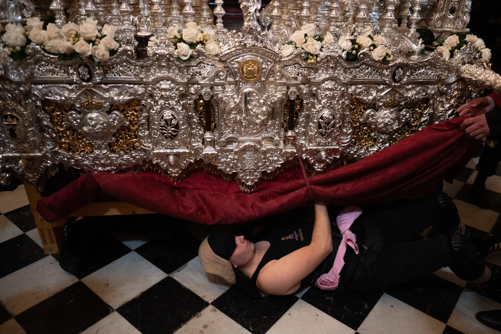 Un portador de una carroza se coloca en posición para levantarla durante la procesión de la hermandad de los "Estudiantes" en Semana Santa en Granada, Andalucía.

Foto: AFP