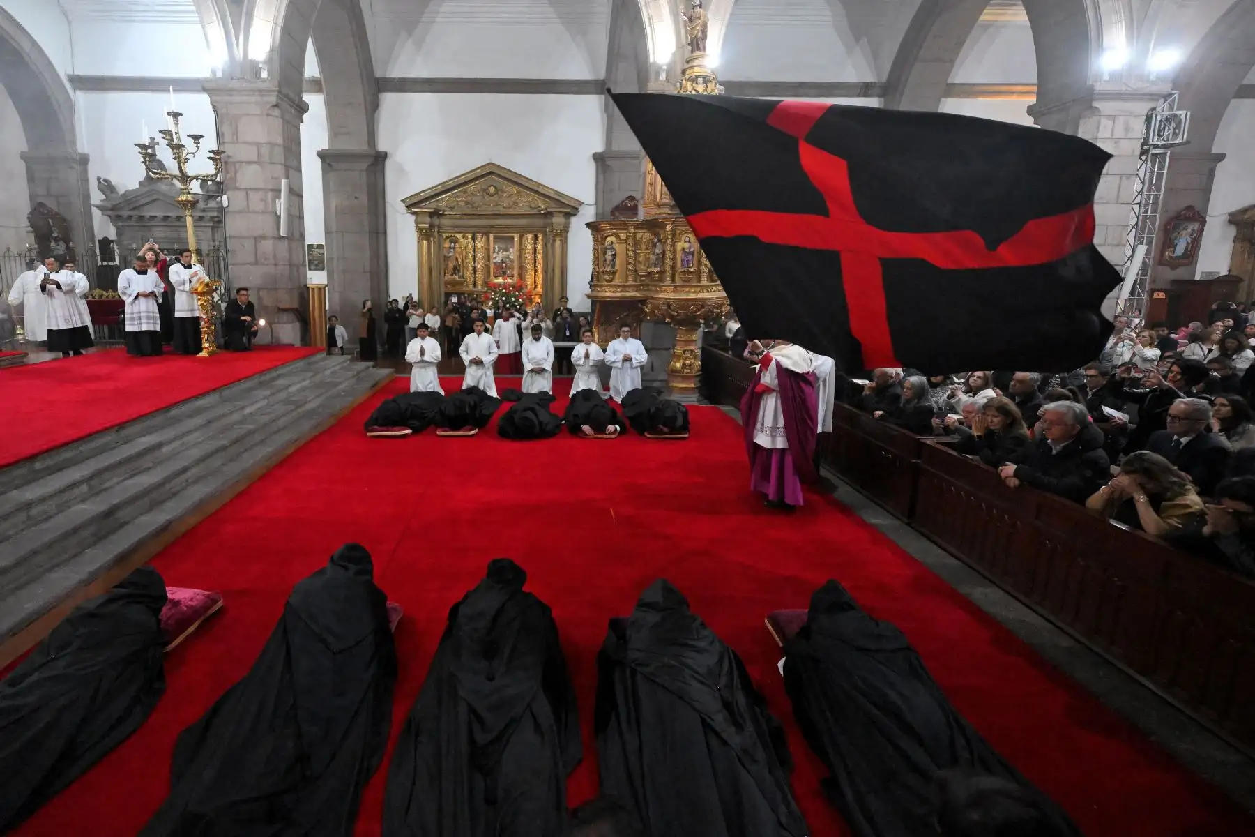 El arzobispo de Quito, Alfredo Espinoza Mateus, ondea una bandera durante la ceremonia del "Arrastre de Caudas" en la Catedral Metropolitana de Quito.

Foto: AFP