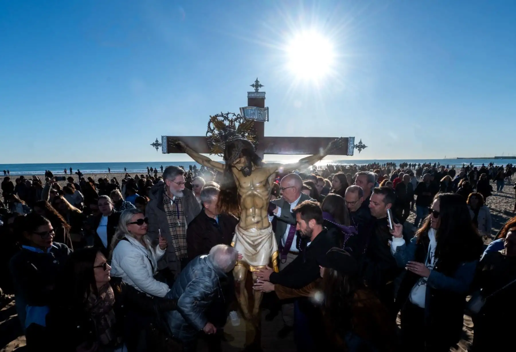 Creyentes tocan una efigie del "Cristo Salvador" durante una procesión de Semana Santa en Valencia el 3 de abril de 2026. Los creyentes cristianos de todo el mundo marcan la semana santa de Pascua en celebración de la crucifixión y resurrección de Jesucristo. (Foto de Jose Jordan / AFP)