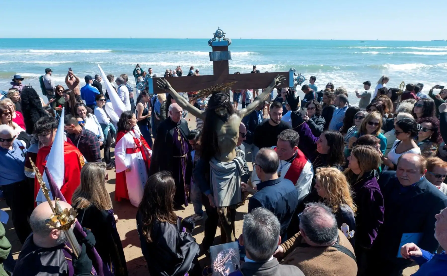 Los penitenciantes llevan una efigie del "Cristo Salvador y del Amparo" durante la Semana Santa en la playa de Valencia el 3 de abril de 2026. Los creyentes cristianos de todo el mundo marcan la semana santa de Pascua en celebración de la crucifixión y resurrección de Jesucristo. (Foto de Jose Jordan / AFP)
