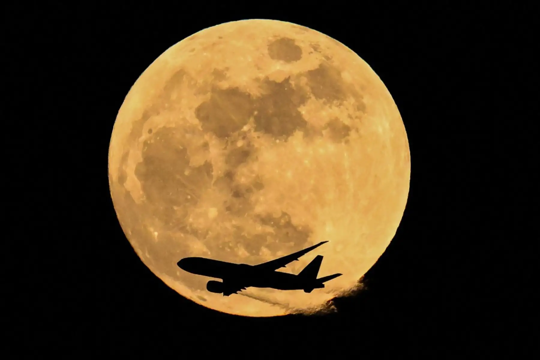 El avión Boeing 777-FFT de la aerolínea de carga Air China sobrevuela la luna llena de abril, también conocida como "Luna Rosa", en Fráncfort del Meno, al oeste de Alemania. Foto: ANDINA/ AFP