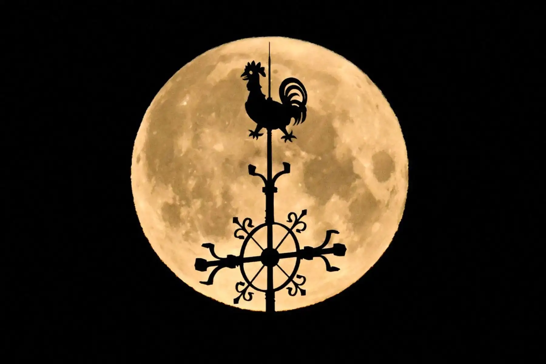 La luna llena de abril, también conocida como "Luna Rosa", se ve detrás de la veleta que corona la Iglesia de los Tres Reyes Magos (Dreikoenigskirche) en Fráncfort del Meno, Alemania Occidental, en la madrugada. Foto: ANDINA/AFP