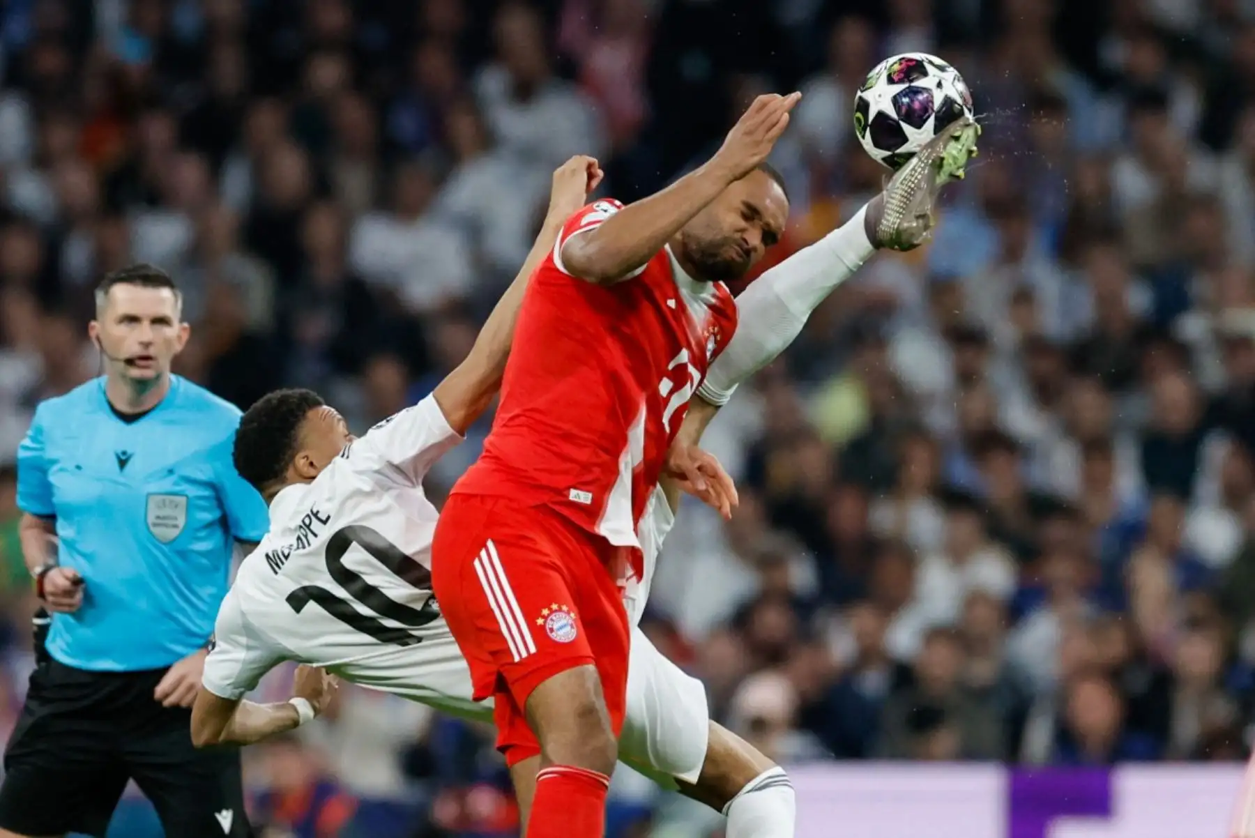 El delantero francés del Real Madrid, Kylian Mbappé  disputa el balón con el defensa alemán del Bayern de Múnich, Jonathan Tah, durante el partido de ida de los cuartos de final de la Liga de Campeones de la UEFA entre el Real Madrid CF y el FC Bayern de Múnich. Foto: AFP