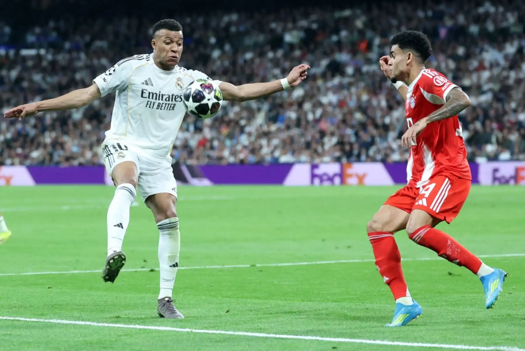 El delantero francés del Real Madrid, Kylian Mbappé , es desafiado por el delantero colombiano del Bayern de Múnich, Luis Díaz, durante el partido de ida de los cuartos de final de la Liga de Campeones de la UEFA entre el Real Madrid CF y el FC Bayern de Múnich. AFP