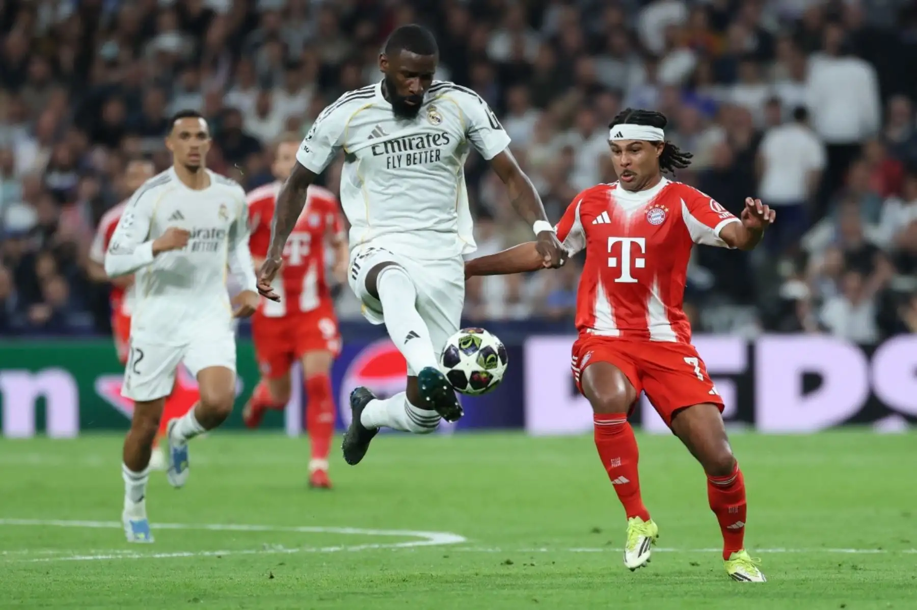 El defensa alemán del Real Madrid, Antonio Rüdiger  patea el balón disputado por el delantero alemán del Bayern de Múnich, Serge Gnabry, durante el partido de ida de los cuartos de final de la Liga de Campeones de la UEFA entre el Real Madrid CF y el FC Bayern de Múnich. AFP