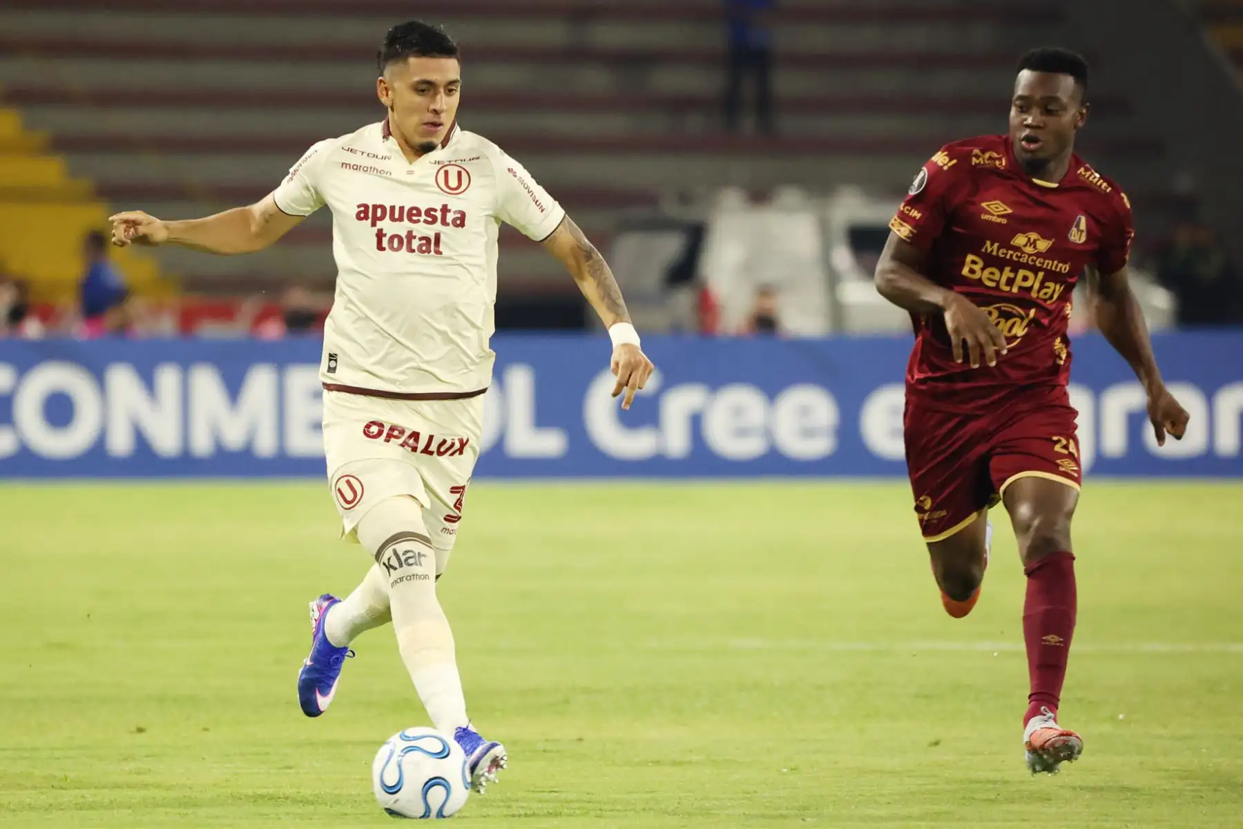 Adrián Parra  de Tolima disputa el balón con César Inga de Universitario este martes, en un partido de la Copa Libertadores entre Tolima y Universitario. Foto: EFE
