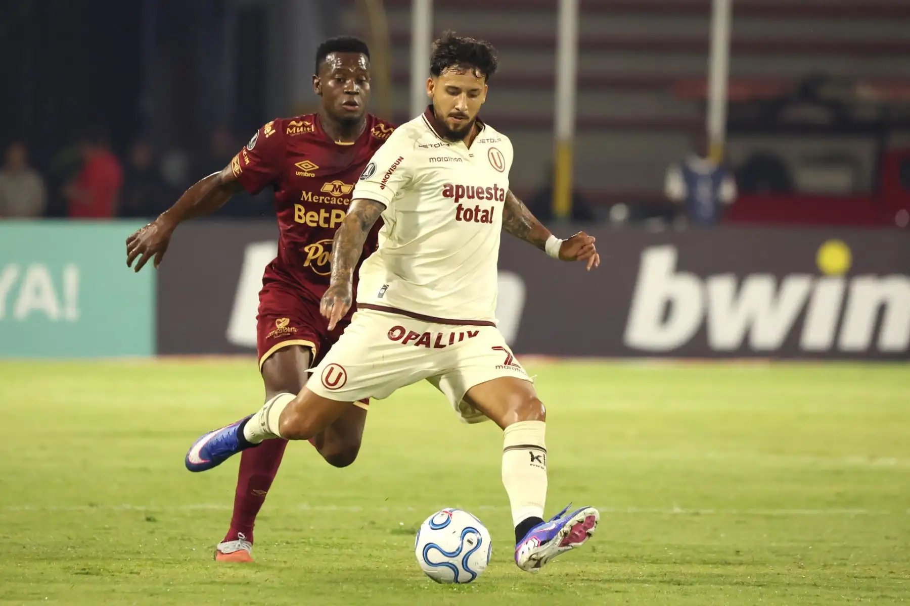 Adrián Parra  de Tolima disputa el balón con Cain Fara de Universitario este martes, en un partido de la Copa Libertadores entre Tolima y Universitario. EFE