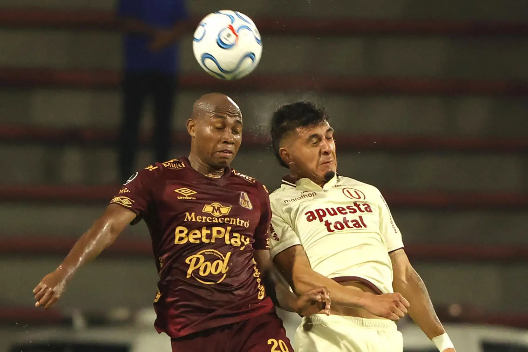 Junior Hernández de Tolima disputa el balón con César Inga de Universitario este martes, en un partido de la Copa Libertadores entre Tolima y Universitario. Foto: EFE