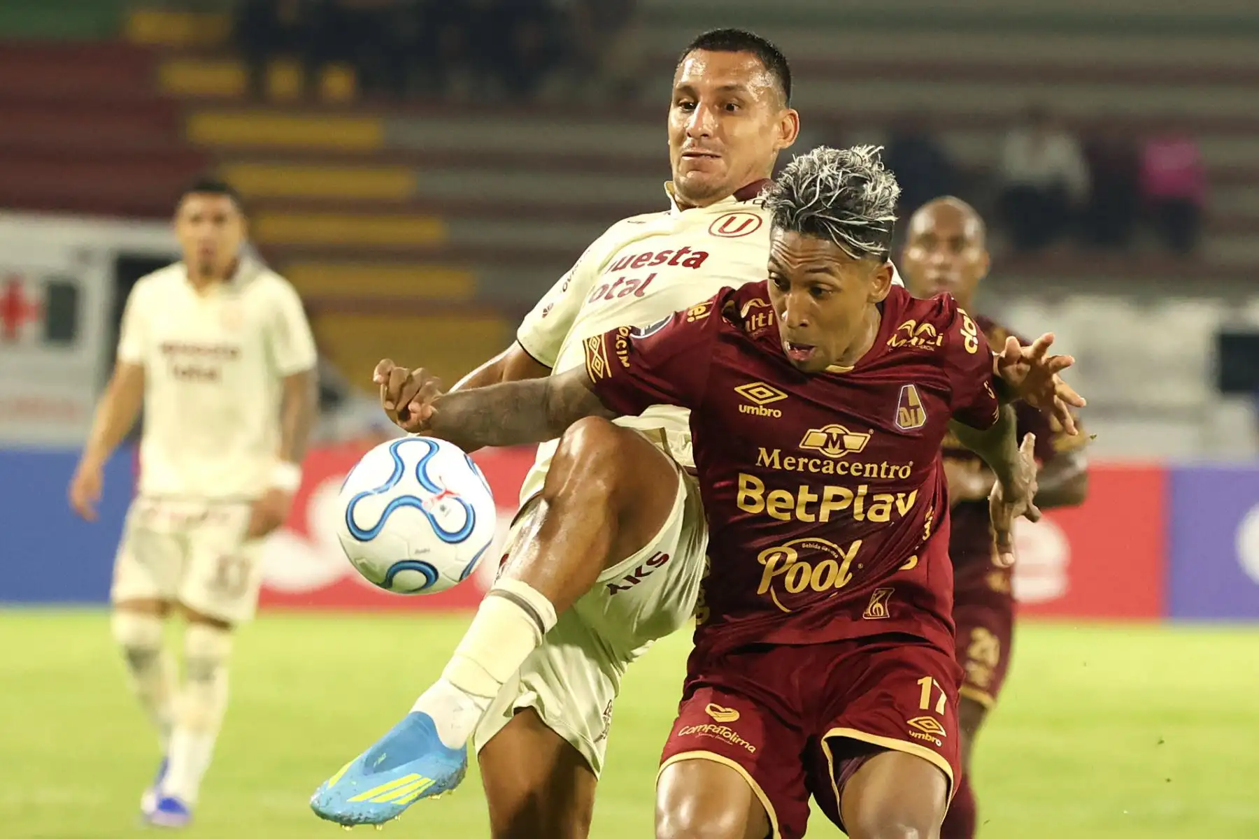 Cristian Arrieta  de Tolima disputa el balón con Álex Valera de Universitario este martes, en un partido de la Copa Libertadores entre Tolima y Universitario. EFE