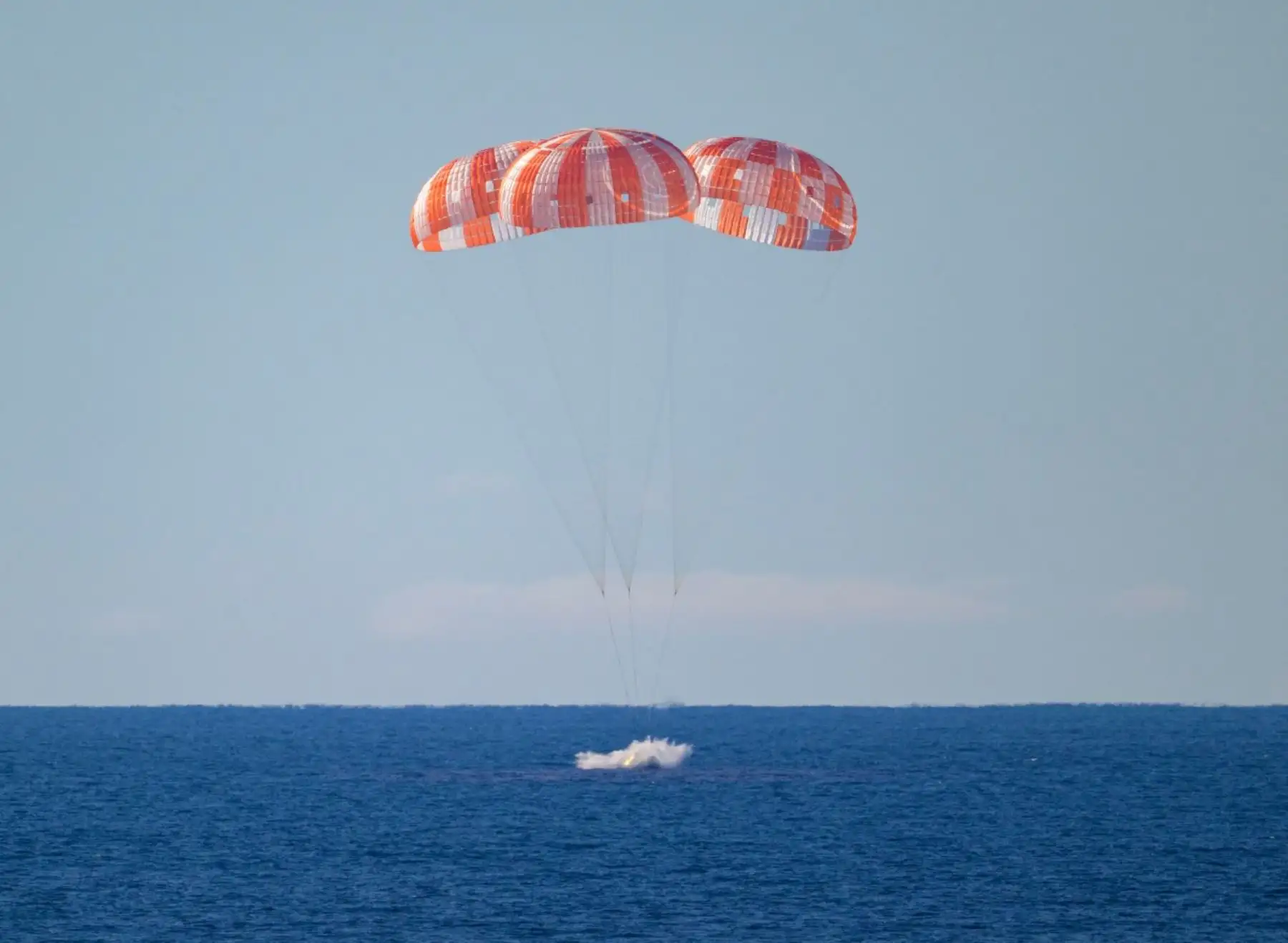 Esta fotografía distribuida por la NASA muestra la nave espacial Orion de la NASA con los tripulantes de Artemis II: el comandante Reid Wiseman, el piloto Victor Glover, la especialista de misión Christina Koch y el especialista de misión de la CSA (Agencia Espacial Canadiense) Jeremy Hansen, al aterrizar en el Océano Pacífico frente a la costa de California. AFP