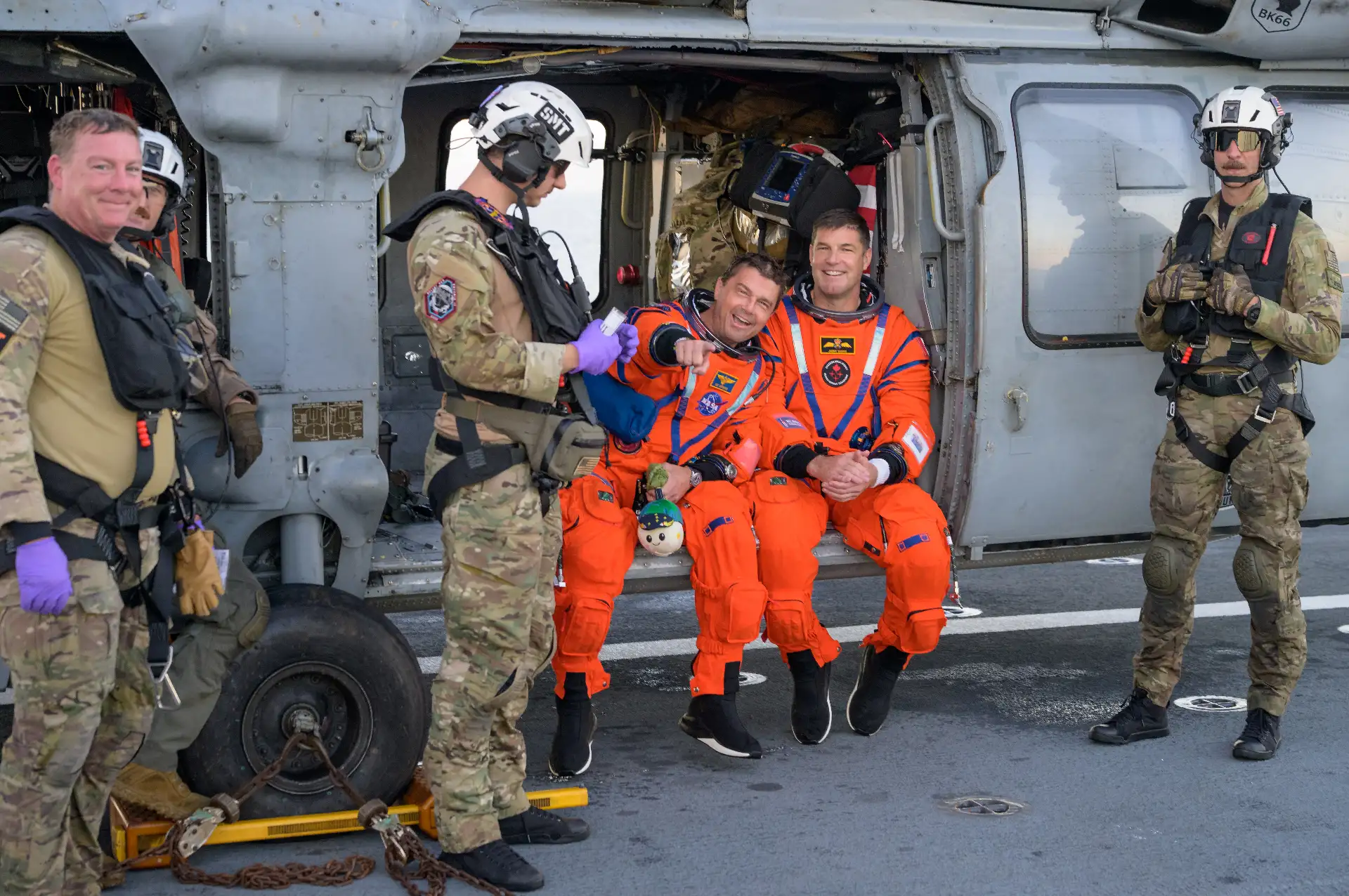 El astronauta de la NASA Reid Wiseman, comandante de Artemis II  y el astronauta de la CSA (Agencia Espacial Canadiense), Jeremy Hansen, especialista de la misión Artemis II, aparecen sentados en un helicóptero MH-60 Seahawk de la Armada, perteneciente al Escuadrón de Combate Marítimo de Helicópteros (HSC) 23, en la cubierta de vuelo del USS John P. Murtha. Crédito de la imagen: NASA/Bill Ingalls