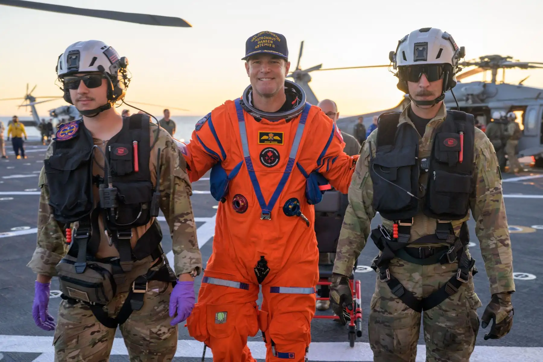 El astronauta de la CSA (Agencia Espacial Canadiense), Jeremy Hansen, especialista de la misión Artemis II, es ayudado a bajar de la cubierta de vuelo tras llegar a bordo del USS John P. Murtha. Crédito de la imagen: NASA/Bill Ingalls
