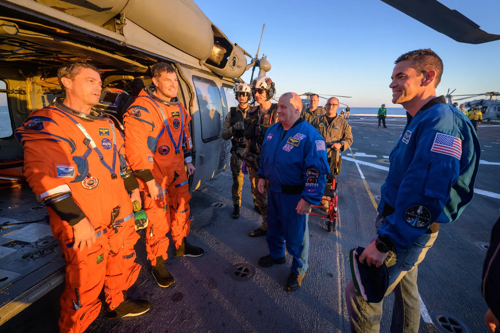 El astronauta de la NASA Victor Glover, piloto de Artemis II y el astronauta de la CSA (Agencia Espacial Canadiense), Jeremy Hansen, especialista de la misión Artemis II, conversan con el administrador de la NASA, Jared Isaacman, en su helicóptero MH-60 Seahawk de la Armada, perteneciente al Escuadrón de Combate Marítimo de Helicópteros (HSC) 23, en la cubierta de vuelo del USS John P. Murtha. .Crédito de la imagen: NASA/Bill Ingalls