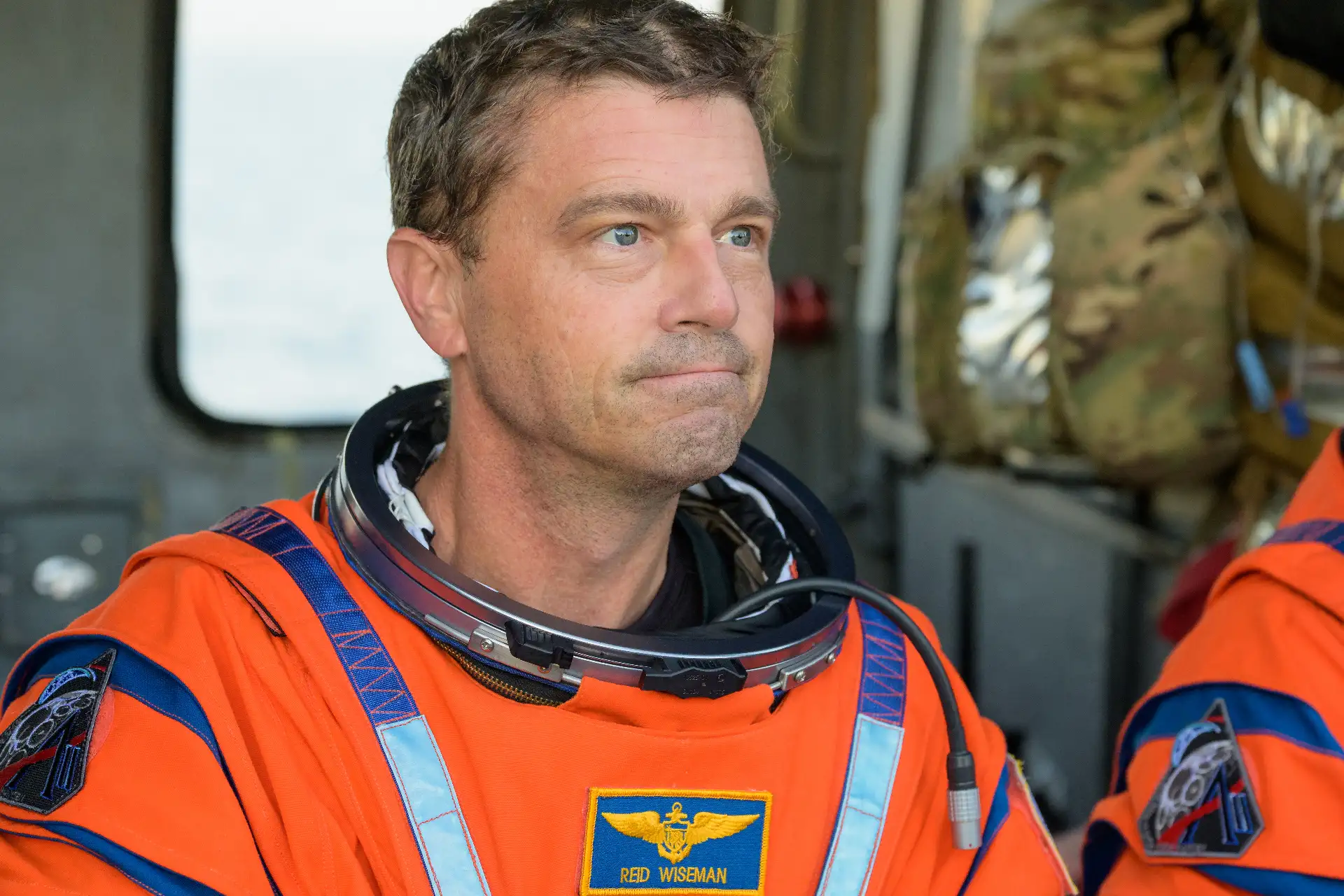 El astronauta de la NASA Reid Wiseman, comandante de la misión Artemis II, aparece sentado en un helicóptero MH-60 Seahawk de la Armada, perteneciente al Escuadrón de Combate Marítimo (HSC) 23, en la cubierta de vuelo del USS John P. Murtha, tras ser rescatado de su nave espacial Orion después del amerizaje. Crédito de la imagen: NASA/Bill Ingalls