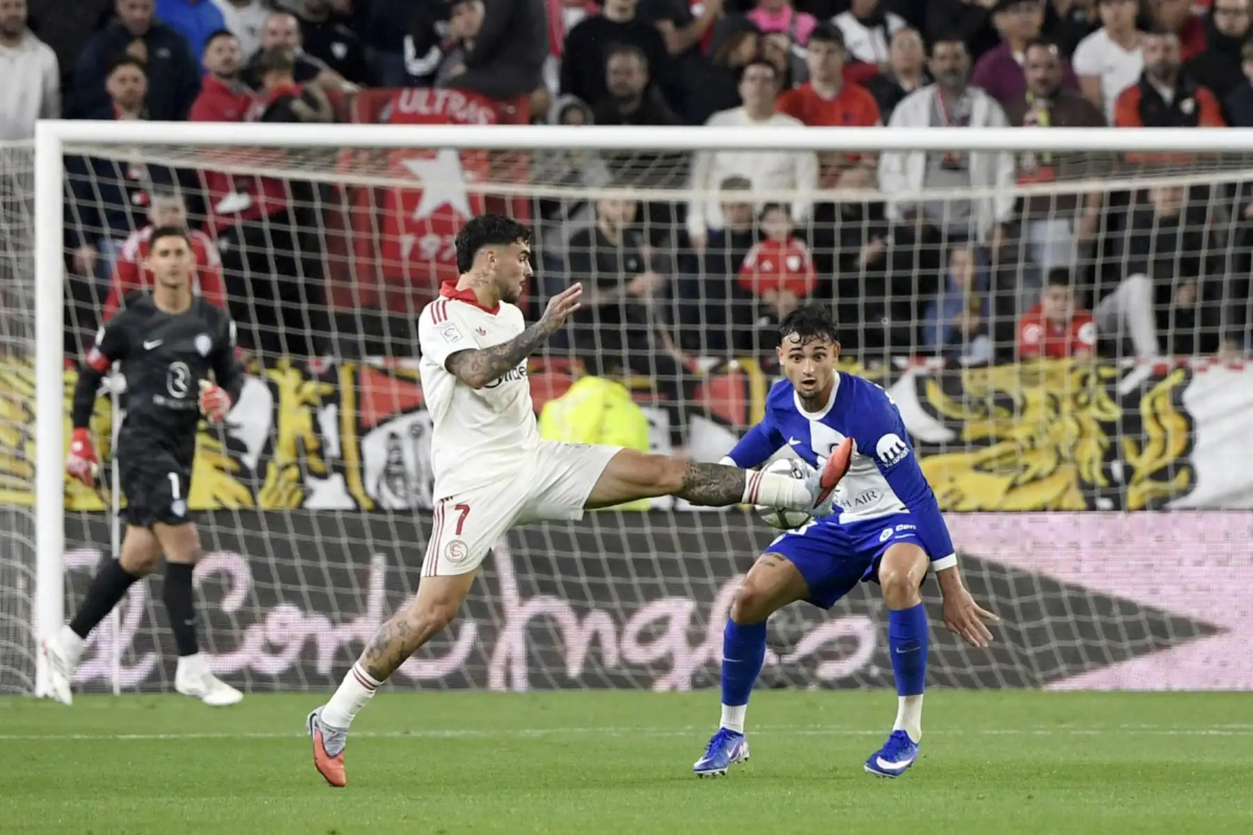 El delantero español del Sevilla, Isaac Romero, disputa el balón con el defensa español del Atlético de Madrid, Marc Pubill, durante el partido de la liga española entre el Sevilla FC y el Club Atlético de Madrid. Foto: ANDINA/AFP