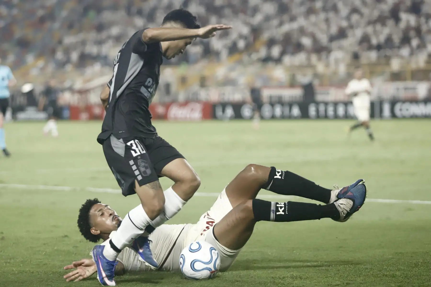 Jesús Castillo Molina (atrás) de Universitario de Deportes disputa un balón con Benjamín Chandía de Coquimbo Unido este martes, en un partido de la fase de grupos de la Copa Libertadores entre Universitario de Deportes y Coquimbo Unido.EFE