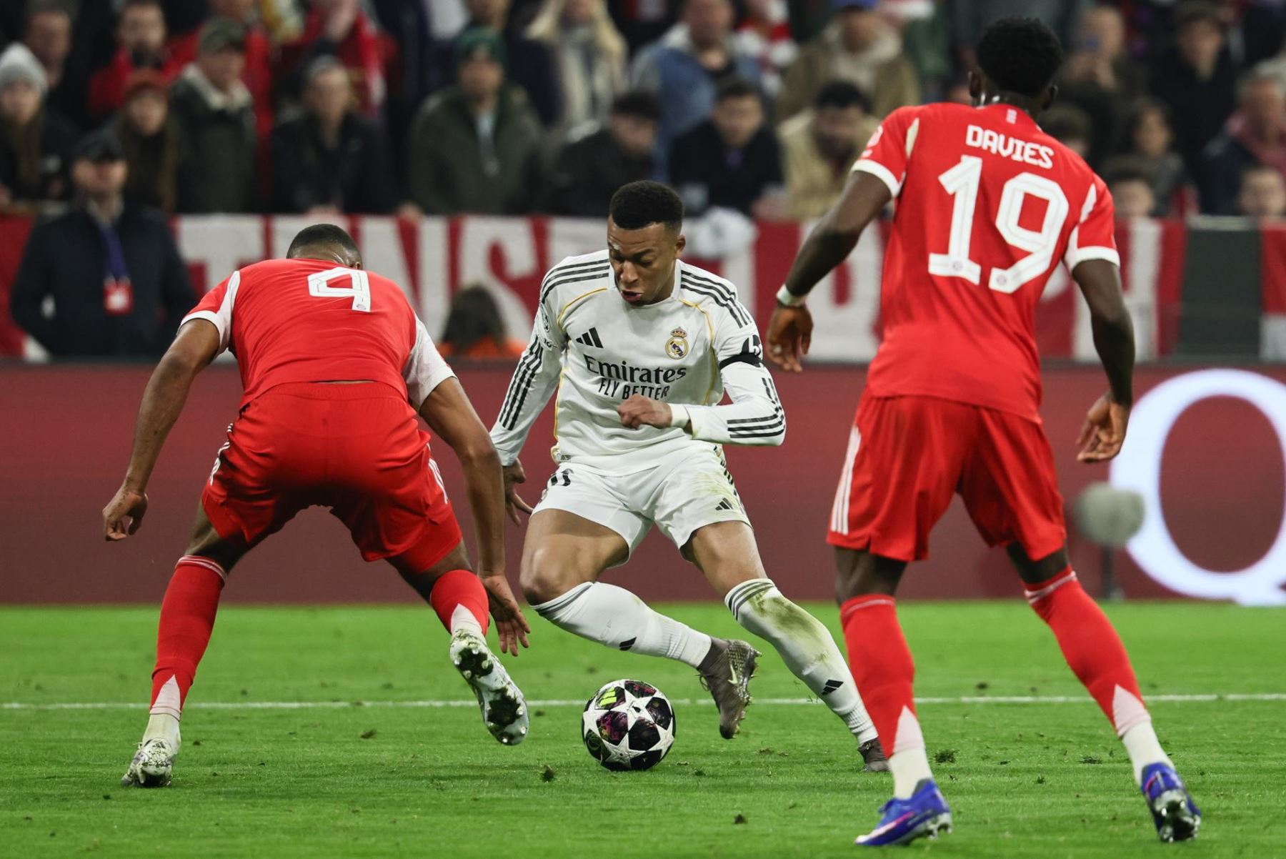 Kylian Mbappé del Real Madrid  en acción contra Jonathan Tah del Bayern de Múnich junto a Alphonso Davies del Bayern de Múnich durante el partido de vuelta de los cuartos de final de la UEFA Champions League entre el FC Bayern de Múnich y el Real Madrid. EFE