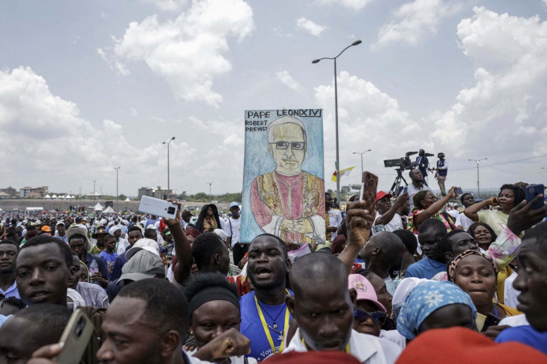 Un fiel sostiene un cartel con la imagen del Papa León XIV mientras el Papa dirige la Santa Misa en el área frente al Estadio Japoma en Douala en el quinto día de un viaje apostólico de 11 días a África, el 17 de abril de 2026. (Foto de Patrick MEINHARDT / AFP)