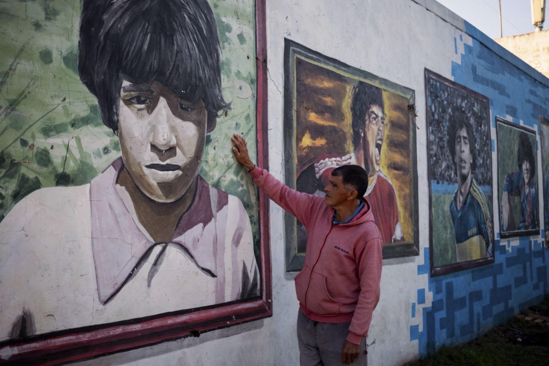 Un hombre toca un mural que representa a la difunta estrella del fútbol Diego Maradona en el barrio de su ciudad natal, Villa Fiorito, en la provincia de Buenos Aires, Argentina. Foto: AFP