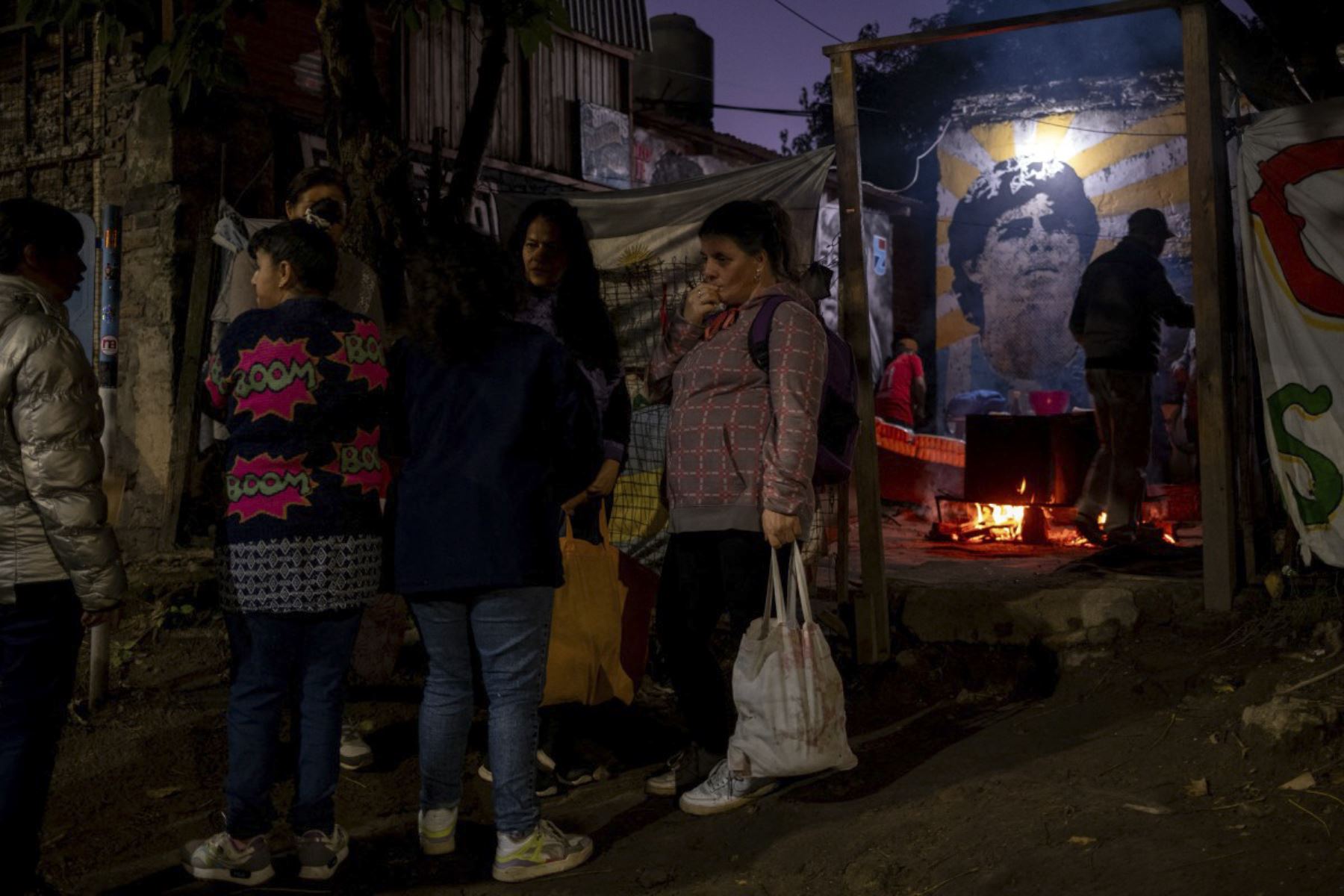 La gente hace cola para recibir comida en el patio de la casa de la infancia de la difunta estrella del fútbol Diego Maradona, ahora transformada en un comedor de beneficencia para vecinos necesitados, en Villa Fiorito, provincia de Buenos Aires, Argentina, el 9 de abril de 2026. Foto: AFP