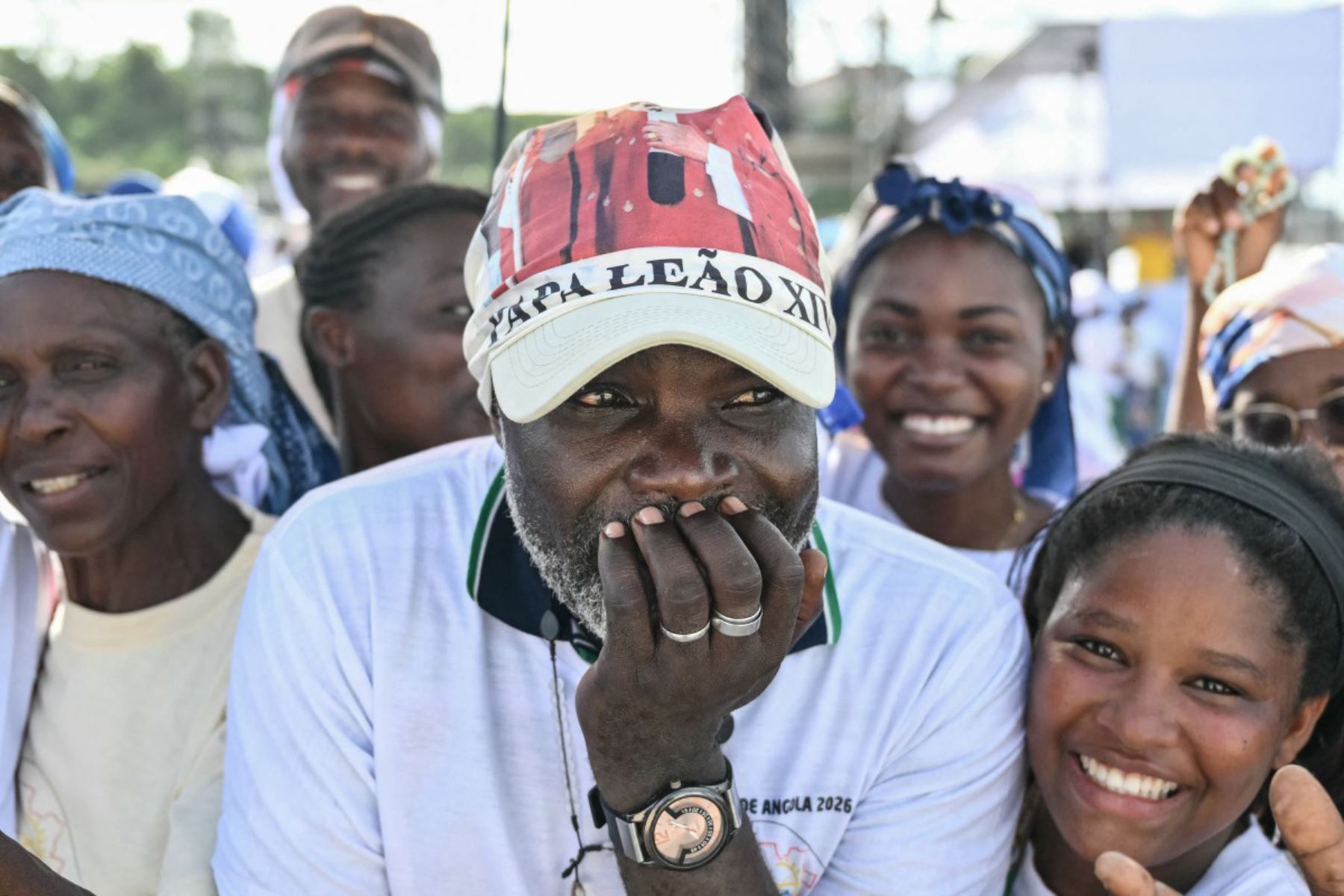 Un fiel reacciona mientras se reúne con otros antes de la llegada del Papa León XIV para dirigir el rezo del Santo Rosario en la explanada frente al Santuario "Mama Muxima" en Muxima, en el séptimo día de una gira apostólica de 11 días por África. Foto: ANDINA/AFP