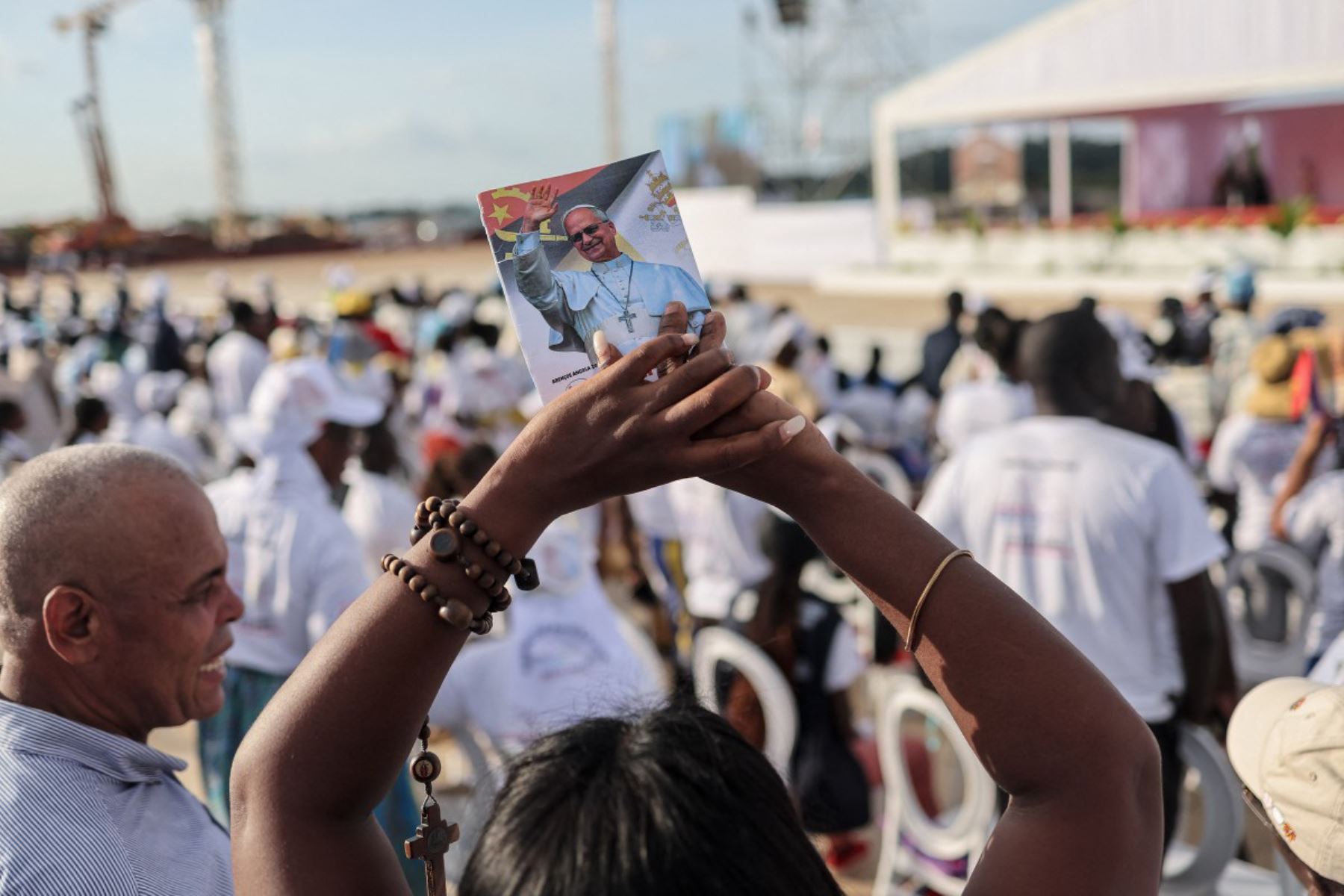 Una fiel sostiene una fotografía del Papa León XIV mientras espera junto a otros su llegada para dirigir el rezo del Santo Rosario en la explanada frente al santuario "Mama Muxima" en Muxima, séptimo día de una gira apostólica de 11 días por África.
Foto: ANDINA/AFP