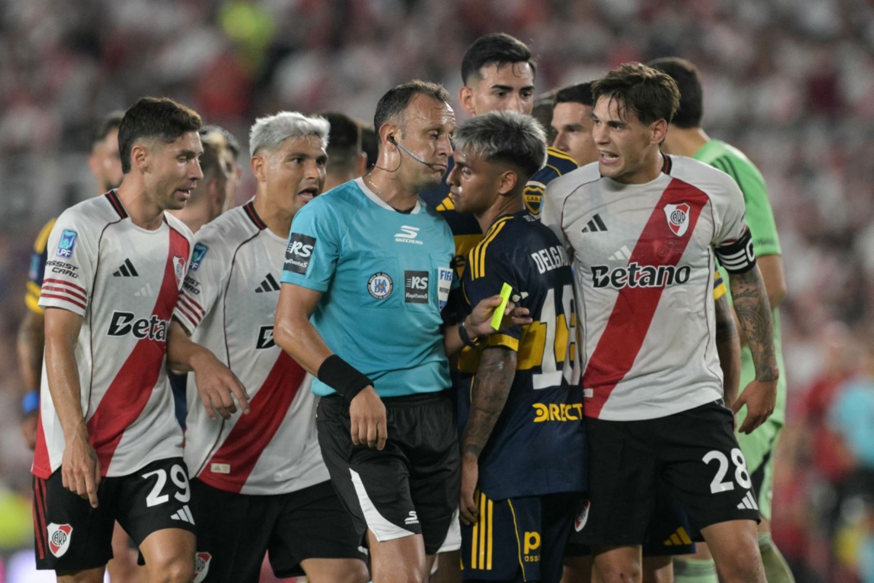 El defensa número 29 de River Plate, Gonzalo Montiel, el delantero número 7, Maximiliano Salas, y el defensa número 28, Lucas Martínez Quarta, discuten con el árbitro argentino Darío Herrera durante el partido del Torneo Apertura 2026 de la Liga Argentina de Fútbol Profesional entre River Plate y Boca Juniors en el estadio MAS Monumental de Buenos Aires el 19 de abril de 2026. (Foto de JUAN MABROMATA / AFP)