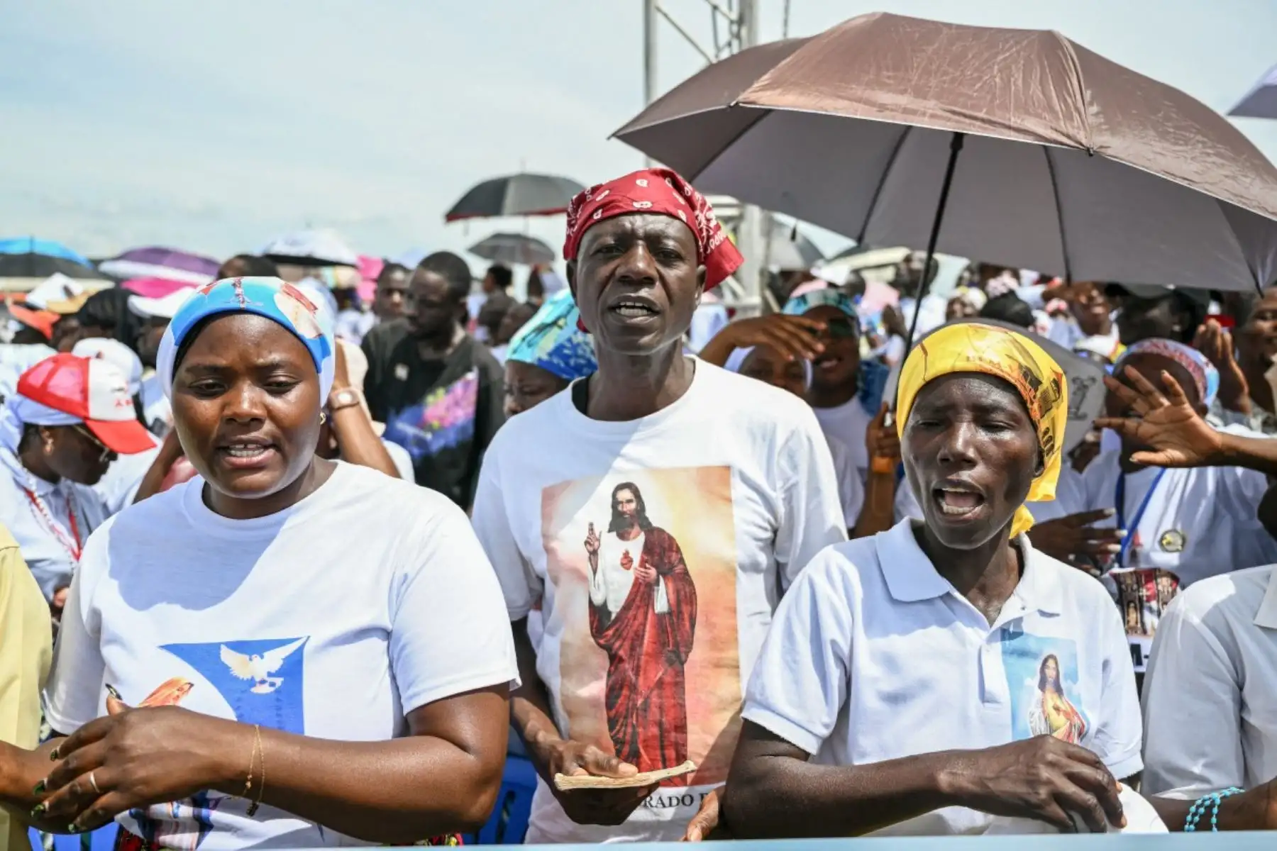 Fieles cantan mientras se congregan antes de la Santa Misa del Papa León XIV en la explanada de Saurimo, en el octavo día de un viaje apostólico de 11 días a África. Foto: AFP