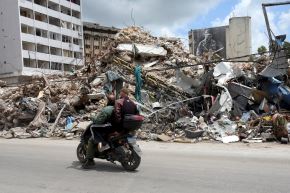 Personas circulan en moto junto a los escombros de un edificio destruido en Nabatieh, sur del Líbano. Foto: AFP