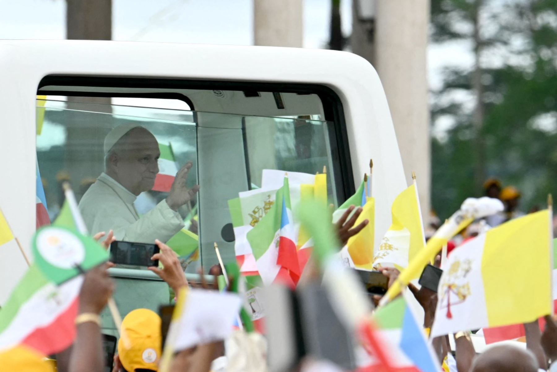 El papa León XIV saluda a la multitud desde el papamóvil a su llegada para oficiar una misa en la Basílica de la Inmaculada Concepción en Mongomo. Foto: AFP