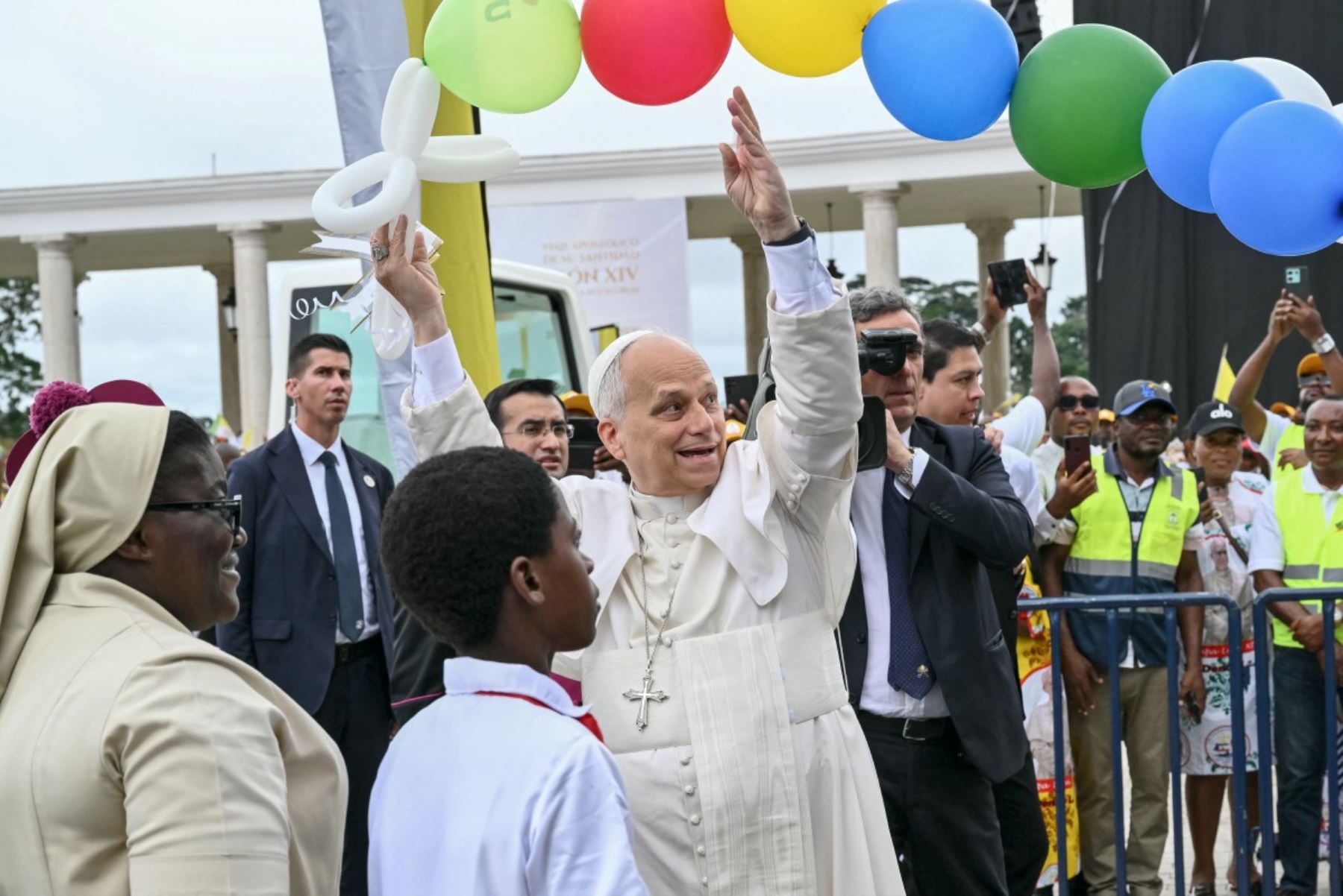El papa León XIV recibe globos de niños a su llegada para oficiar una misa en la Basílica de la Inmaculada Concepción en Mongomo. Foto: AFP